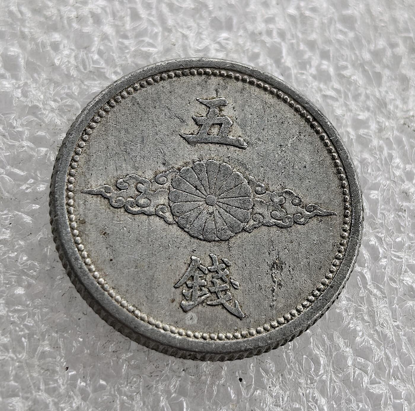 外国优质老铜币高银银币，周六九点倒数截拍，满百包邮，持续收拍 昭和十五年（1940 年）日本五钱铝币，正面 “大日本 昭和十五年” 配飞鸟纹（军国主义象征），背面 “五钱”、皇室菊纹与祥云。二战时期日本金属匮乏改用铝铸，是战时经济与军国主义扩张的货币实物见证。