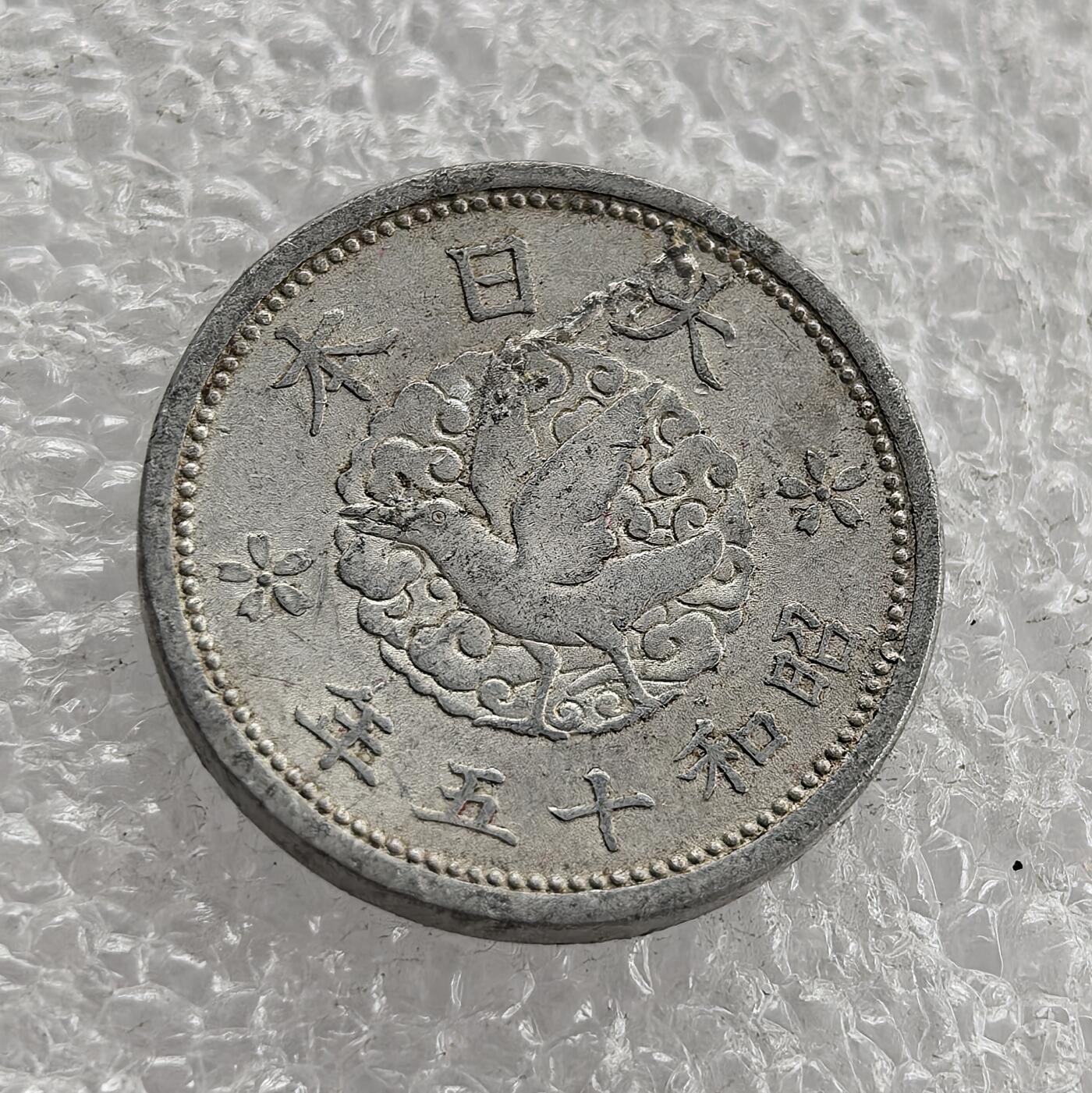 外国优质老铜币高银银币，周六九点倒数截拍，满百包邮，持续收拍 昭和十五年（1940 年）日本一钱铝币，正面皇室菊纹、海浪纹配 “一钱”，彰显皇权与海洋意象；背面 “大日本 昭和十五年”、飞鸟与樱花纹。二战时期日本金属匮乏改用铝铸，是战时经济与军国主义扩张的货币实物见证。