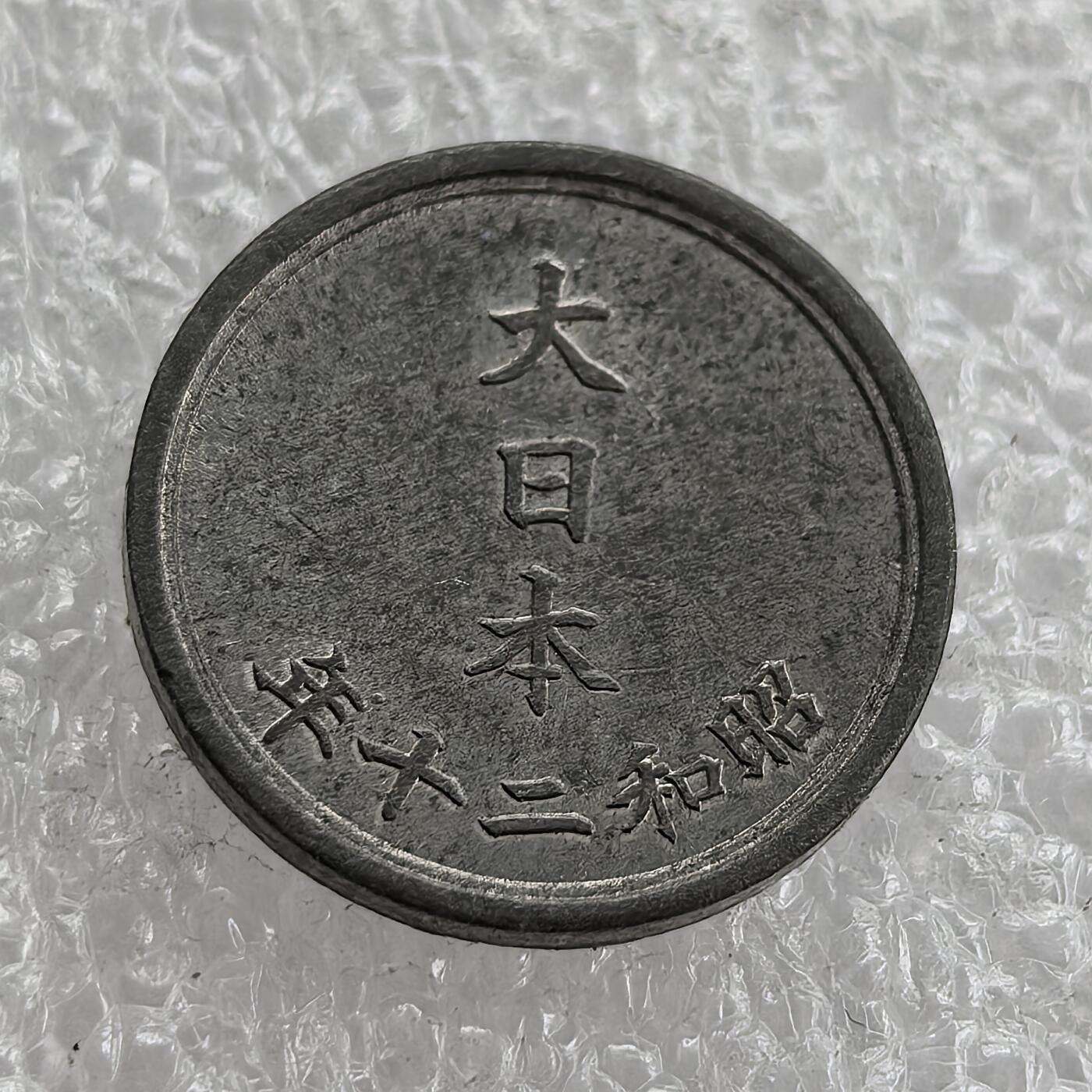 外国优质老铜币高银银币，周六九点倒数截拍，满百包邮，持续收拍 极美品昭和二十年（1945 年）日本一钱锡币，正面皇室菊纹彰显皇权，火焰纹为装饰；背面 “大日本”“昭和二十年” 标注国名与年号。二战末期日本物资匮乏，改用锡铸币，是战时经济崩溃、军国主义走向末路的货币见证