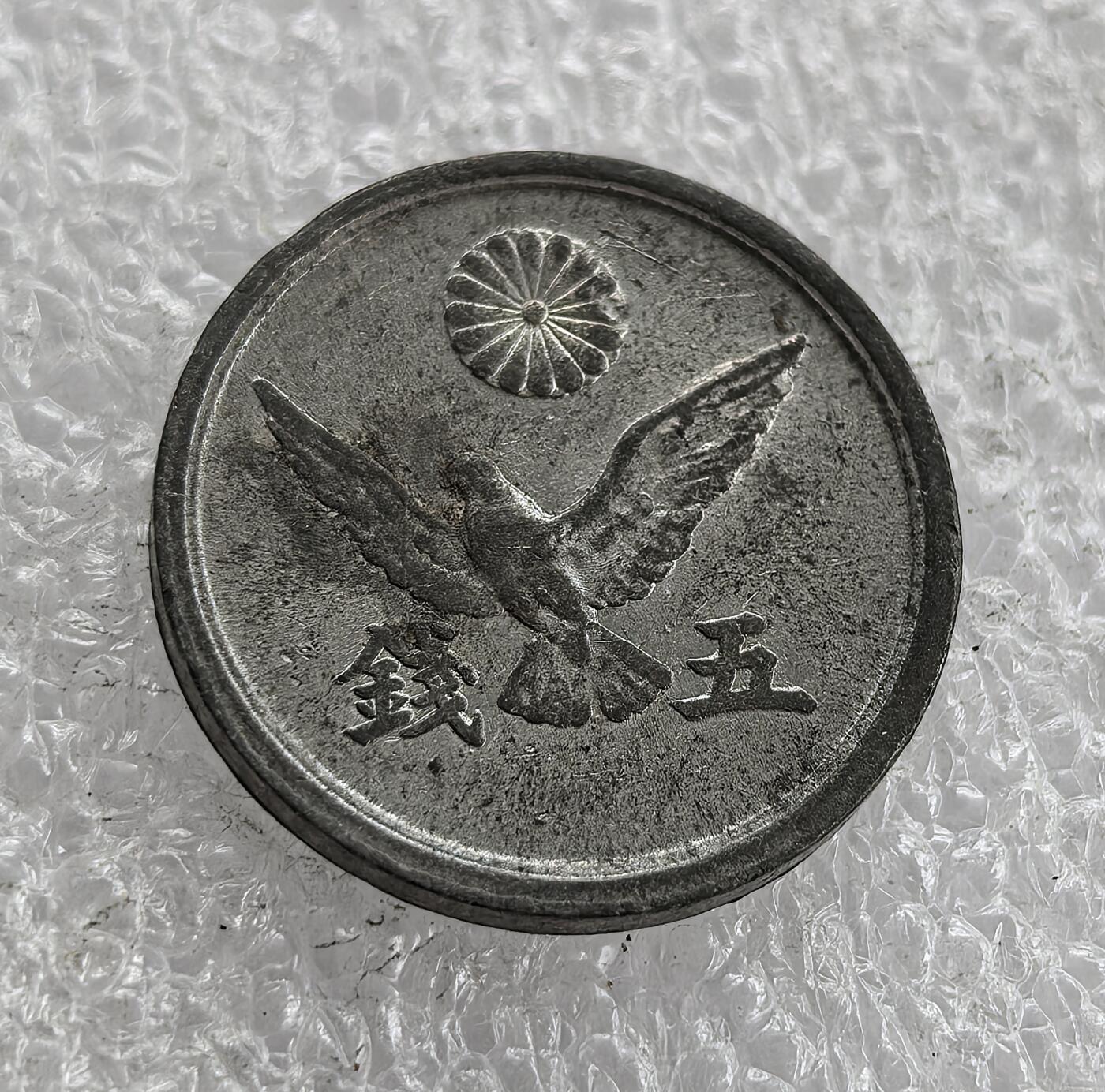 外国优质老铜币高银银币，周六九点倒数截拍，满百包邮，持续收拍 极美品昭和二十一年（1946 年）日本五钱锡币，正面铸 “日本政府”“昭和二十一年” 与数字 5，樱花点缀；背面皇室菊纹、和平鸽及 “五钱”。二战后日本金属匮乏改用锡铸，和平鸽图案折射战后对和平的渴望，是日本战后初期货币与社会转型的实物见证。