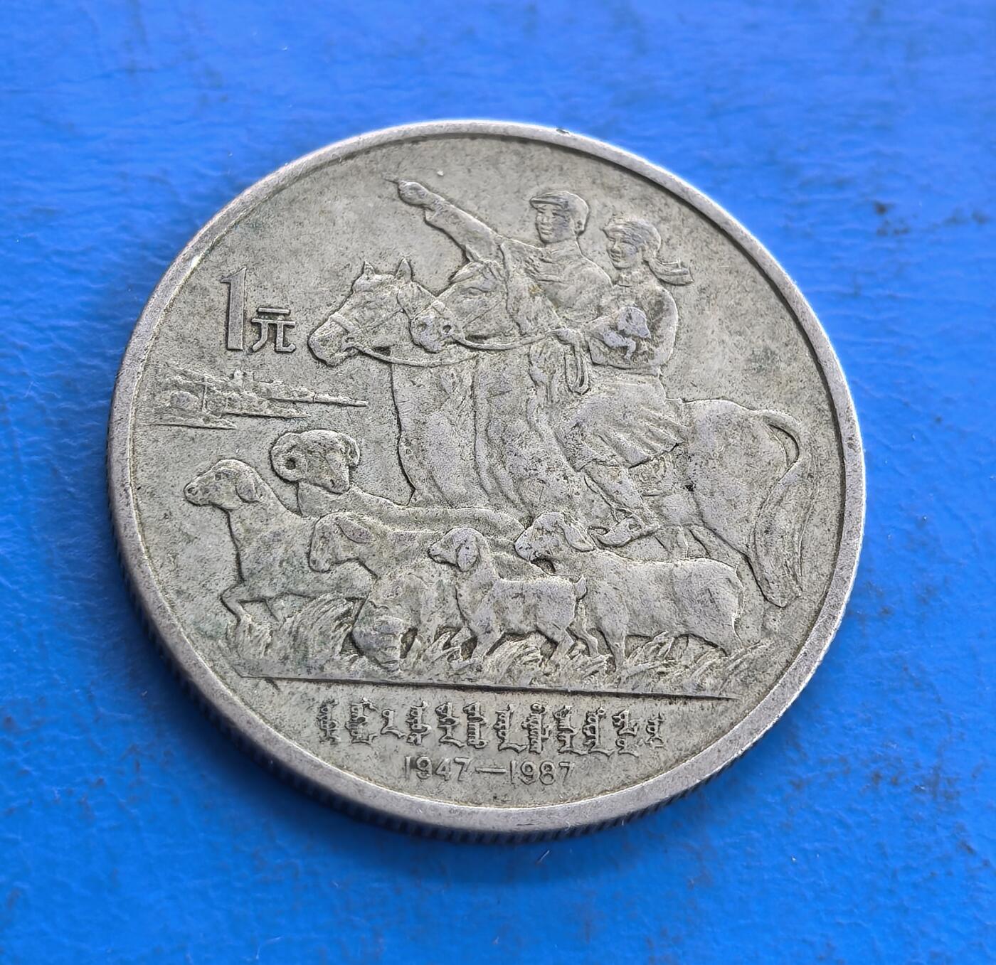 外国优质老铜币高银银币，周六九点倒数截拍，满百包邮，持续收拍 内蒙古自治区1987 年成立四十周年 1 元纪念币，正面铸政府大楼与纪念文字，背面刻画牧民骑马、羊群场景，蒙文与年份点缀，雕刻细腻，民族风情浓郁，兼具历史纪念价值与工艺美感。