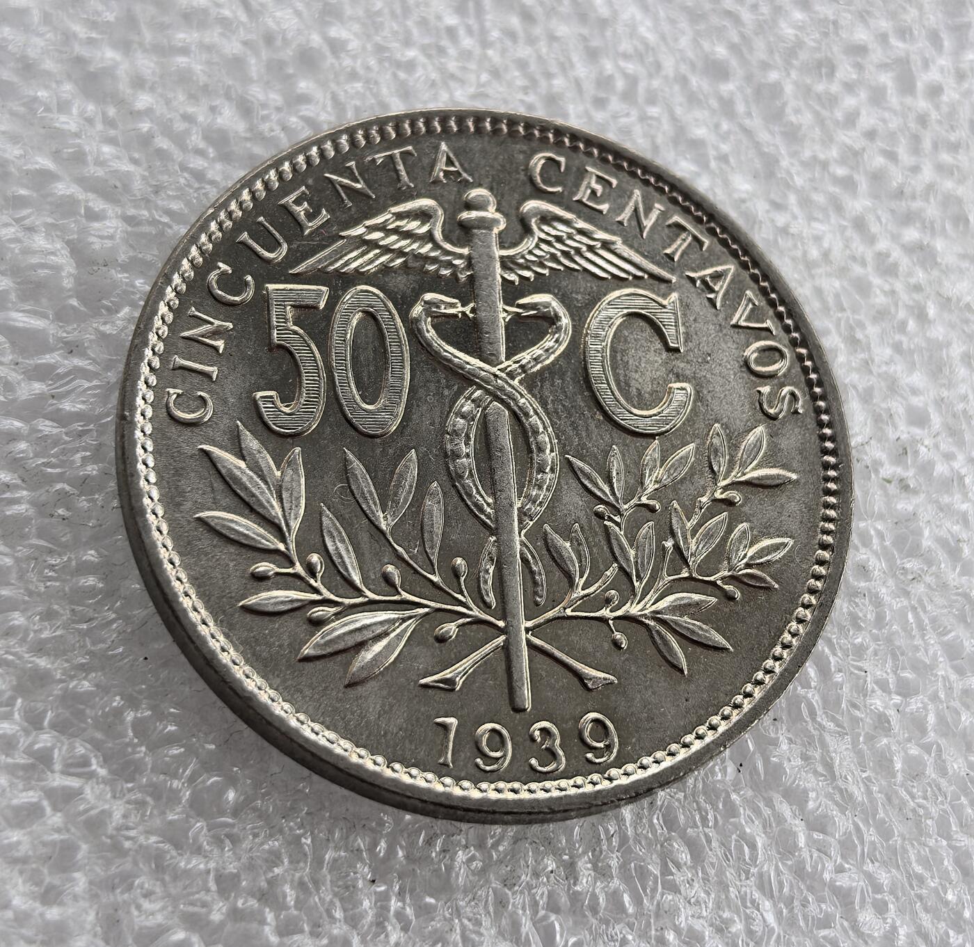 外国优质老铜币高银银币，周六九点倒数截拍，满百包邮，持续收拍 极美品1939 年玻利维亚50分，正面铸双蛇杖（商业象征）、面值与年份，背面为玻利维亚国徽（太阳、山峰、羊驼等）及国名。属玻利维亚共和国时期，是该国独立后，融合本土文化与商业符号的流通货币，见证其经济与国家象征的发展。