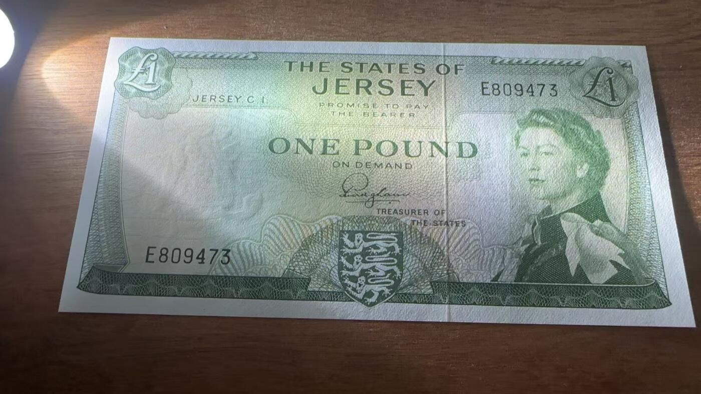 徐霞客拍卖首拍 泽西岛	P-8a 1963年1镑		E809473		unc-	泽西岛作为英国皇家属地，这张纸币发行于战后经济稳定期，是英联邦体系下地方货币自治的体现，币面伊丽莎白二世肖像与泽西岛纹章（持狮图案）结合，既彰显英王室的政治关联，又保留了泽西岛的本土身份标识，反映了属地的双重文化属性。作为泽西岛独立发行的法定货币，它是研究20世纪末英皇家属地货币体系、区域金融关系的重要资料。	