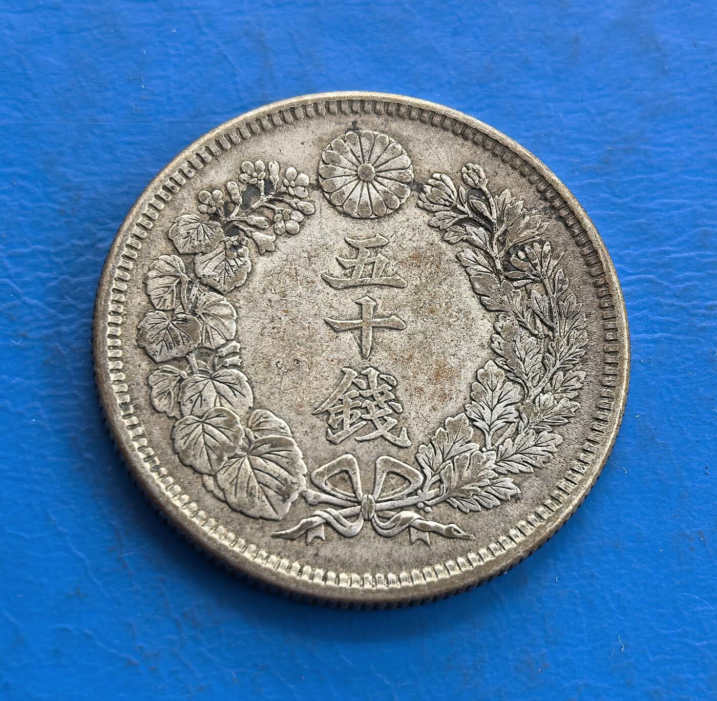 外国优质老铜币高银银币，周六九点倒数截拍，满百包邮，持续收拍 日本大正二年（1913 年）五十钱银币，正面以 “五十钱” 为核心，环绕桐叶、菊花纹与蝴蝶结，尽显日式典雅；背面是放射状旭日纹，搭配 “50 SEN” 与纪年，象征明治维新后的国运升腾，兼具历史与工艺价值。