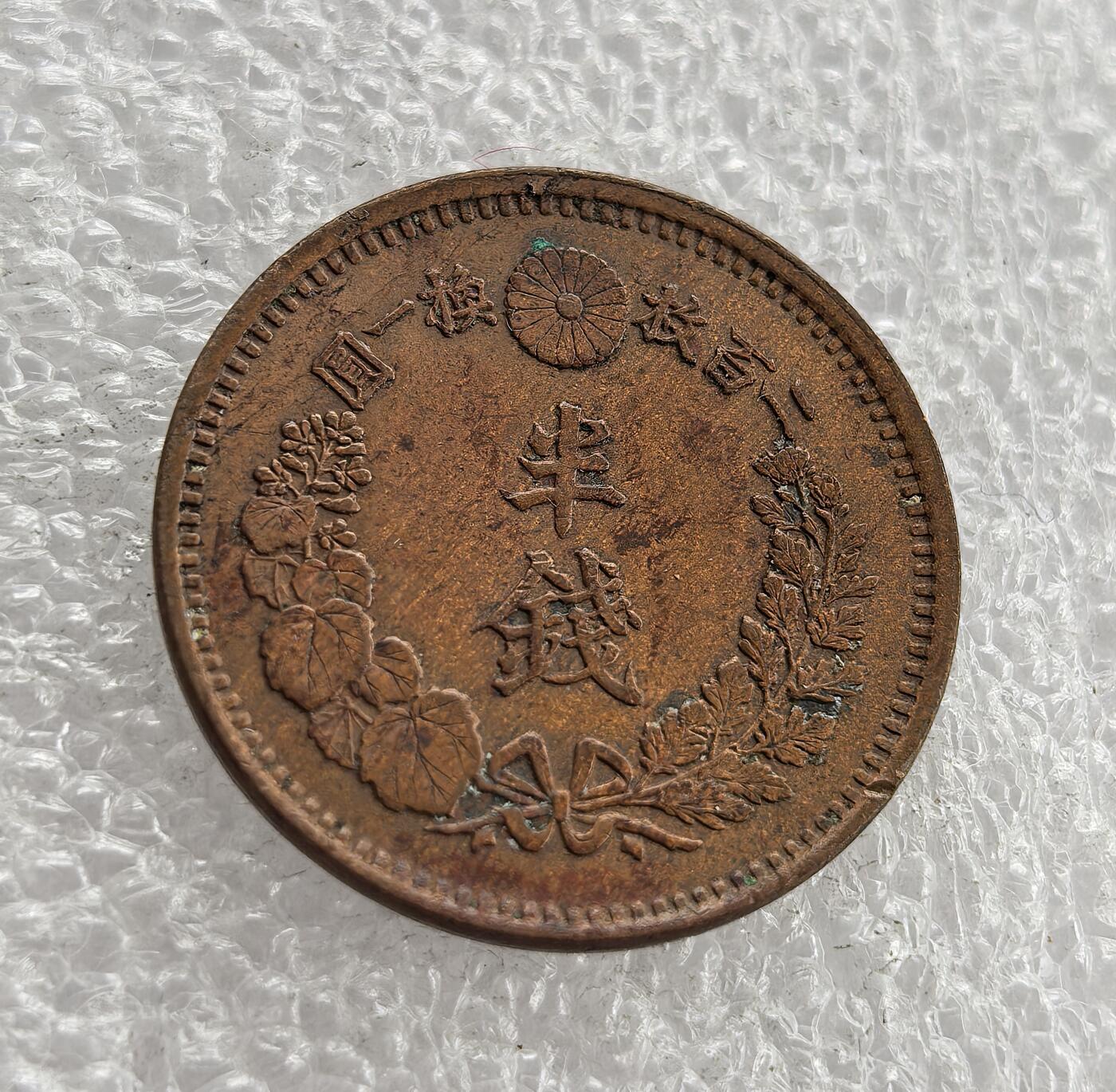 外国优质老铜币高银银币，周六九点倒数截拍，满百包邮，持续收拍 日本明治六年半钱铜币，正面铸龙纹、国名与面值，背面饰半钱、桐叶菊纹及兑换比例，属明治时期经典龙纹辅币。百年铜质包浆自然醇厚，龙纹清晰、品相完整，是东亚近代货币收藏的精品，历史与收藏价值兼具。