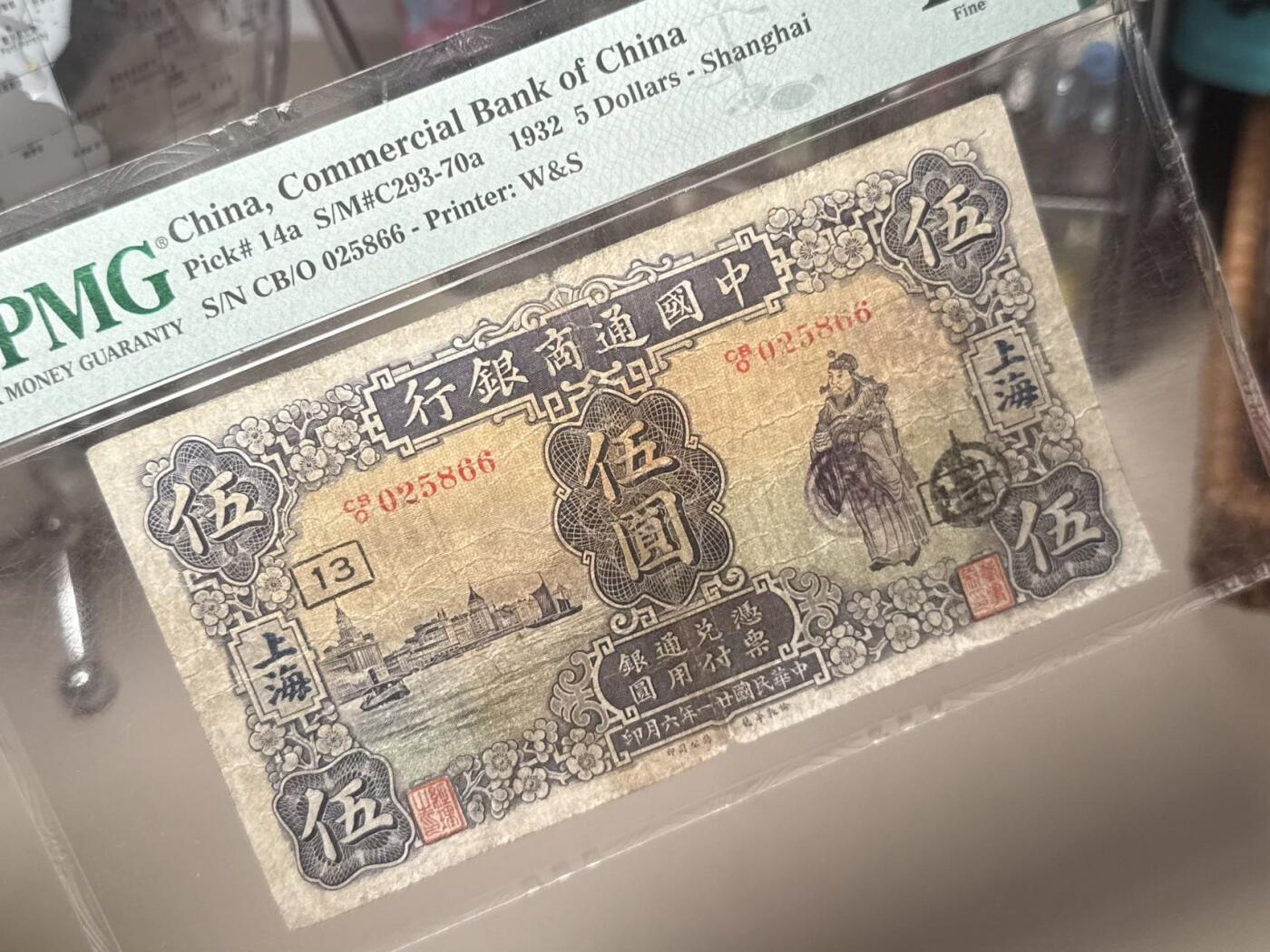 （自动截拍）PMG评级民国纸币专拍第20260131期，全场包邮 【乾奕收藏】出民国21年1932年中国通商银行上海地名伍圆，美国PMG12分，无背标，中间小透，号码全程无347双尾66双喜号， 左侧外滩，右财神图案