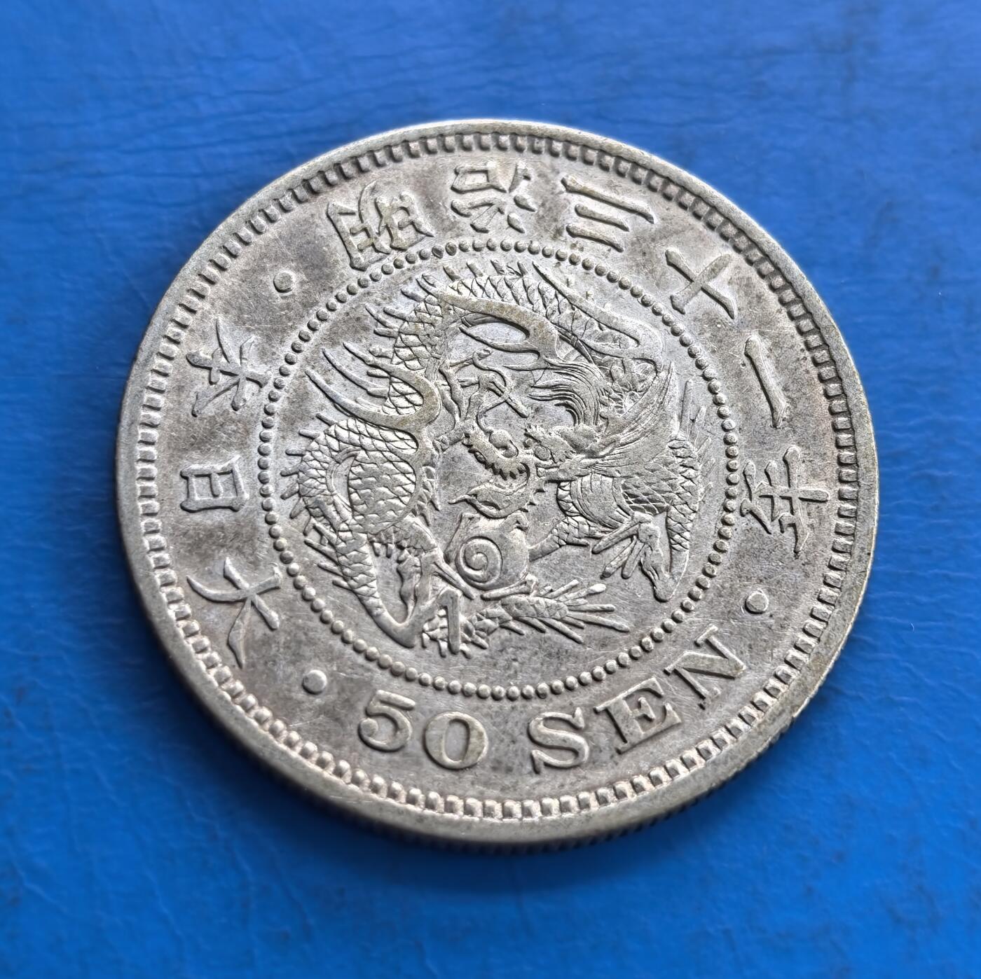 外国优质老铜币高银银币，周六九点倒数截拍，满百包邮，持续收拍 日本明治三十一年五十钱银币，正面樱花、桐叶、菊纹，细节典雅；背面的 “龙纹” 威严精细，币面英文与纪年相衬，兼具历史厚重感与工艺美感。