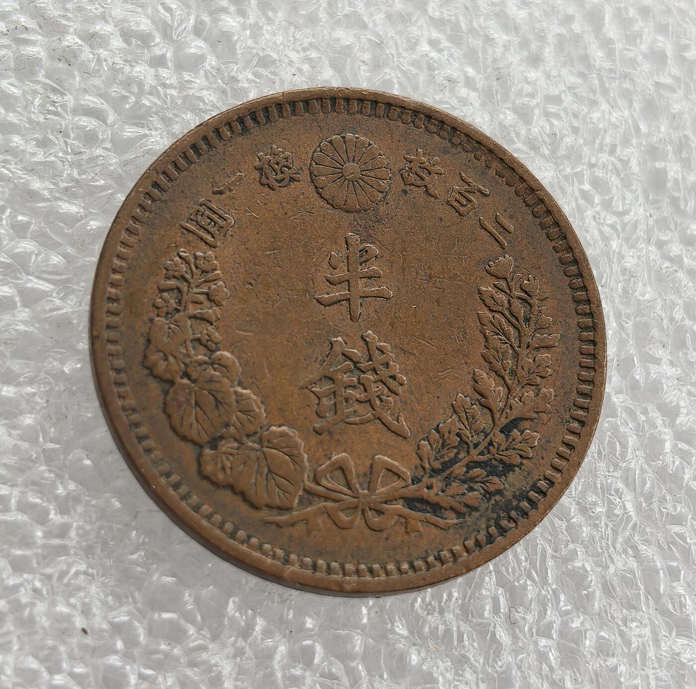 外国优质老铜币高银银币，周六九点倒数截拍，满百包邮，持续收拍 日本明治十五年半钱铜币，正面龙纹刻画精细，搭配国名与面值；背面饰半钱、桐叶菊纹及兑换比例，设计典雅。百年铜质包浆自然醇厚，品相完整，是明治时期龙纹辅币精品，东亚近代货币收藏优选。