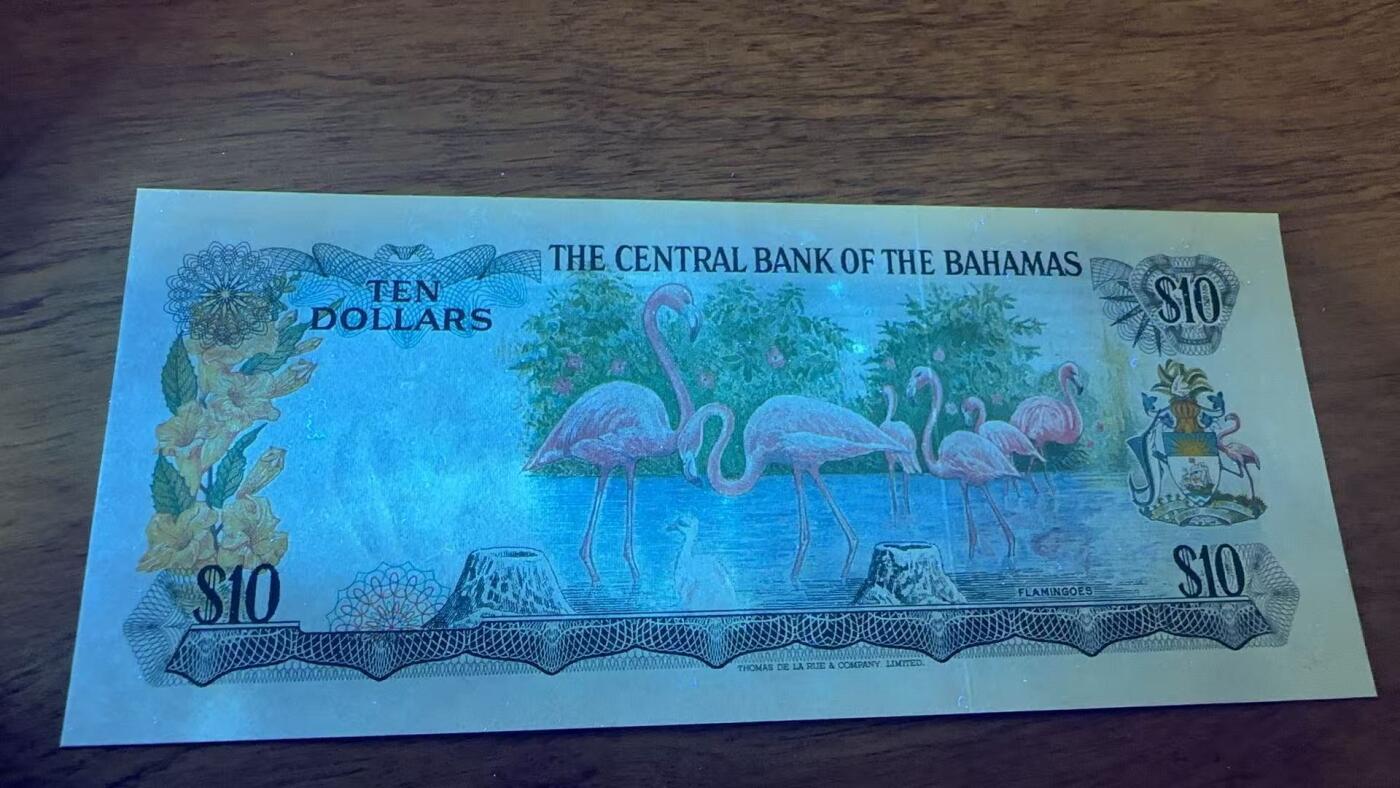 徐霞客拍卖首拍 	巴哈马群岛	P-38a 1974年10元				J645661	unc-纸币正面以伊丽莎白二世肖像为核心设计元素，体现英联邦国家的历史关联。该币是巴哈马独立后首批发行的法定货币，反映其政治转型与经济自主的进程。采用西班牙大帆船水印、精细雕刻凹印及多色套印技术防伪，背面的海洋生物与岛屿图案则展现巴哈马的自然地理特征。		