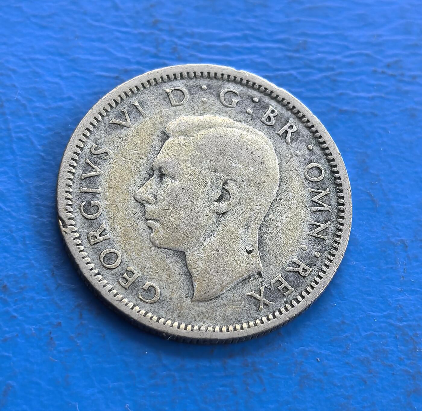 外国优质老铜币高银银币，周六九点倒数截拍，满百包邮，持续收拍 英国1945 年 6 便士银币，正面乔治六世头像雕刻细腻传神，铭文环绕排布规整；背面皇冠衬 GRVI 花押，面值、年份清晰醒目，纹饰庄重典雅，银质包浆温润，尽显二战时期英伦钱币的精湛工艺与经典美学。