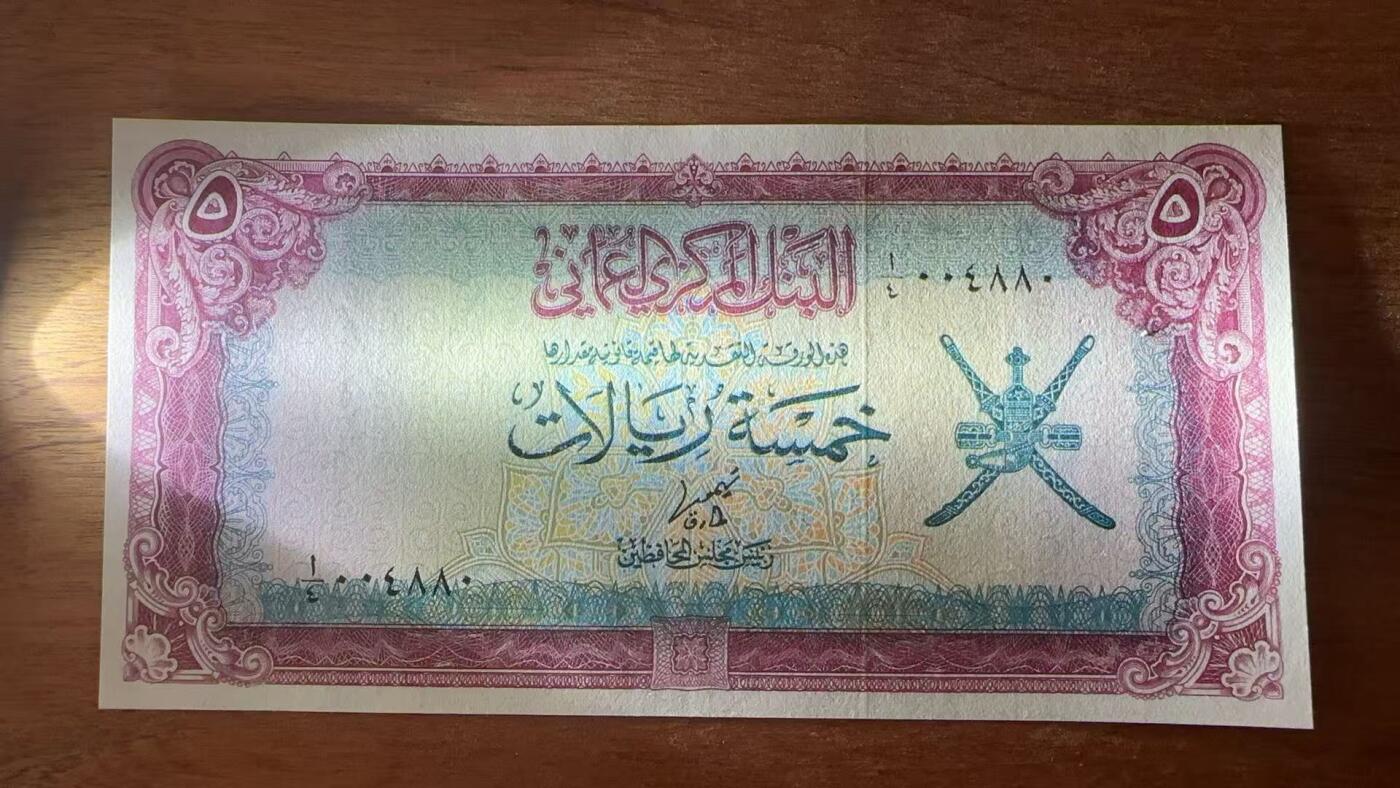 徐霞客拍卖首拍 阿曼	P-18a 1977年5里亚尔 A/4 004880	unc-	阿曼苏丹国5里亚尔纸币 正面以阿拉伯书法标注面额，配阿曼国徽核心双剑纹章，彰显王室权威与伊斯兰属性。 发行于阿曼现代化建设初期，见证该国从传统经济向油气经济转型。 背面为清真寺图案，呼应伊斯兰宗教核心地位。 币面融合阿拉伯书法艺术与伊斯兰纹样设计，采用红、蓝、金三色套印工艺。		