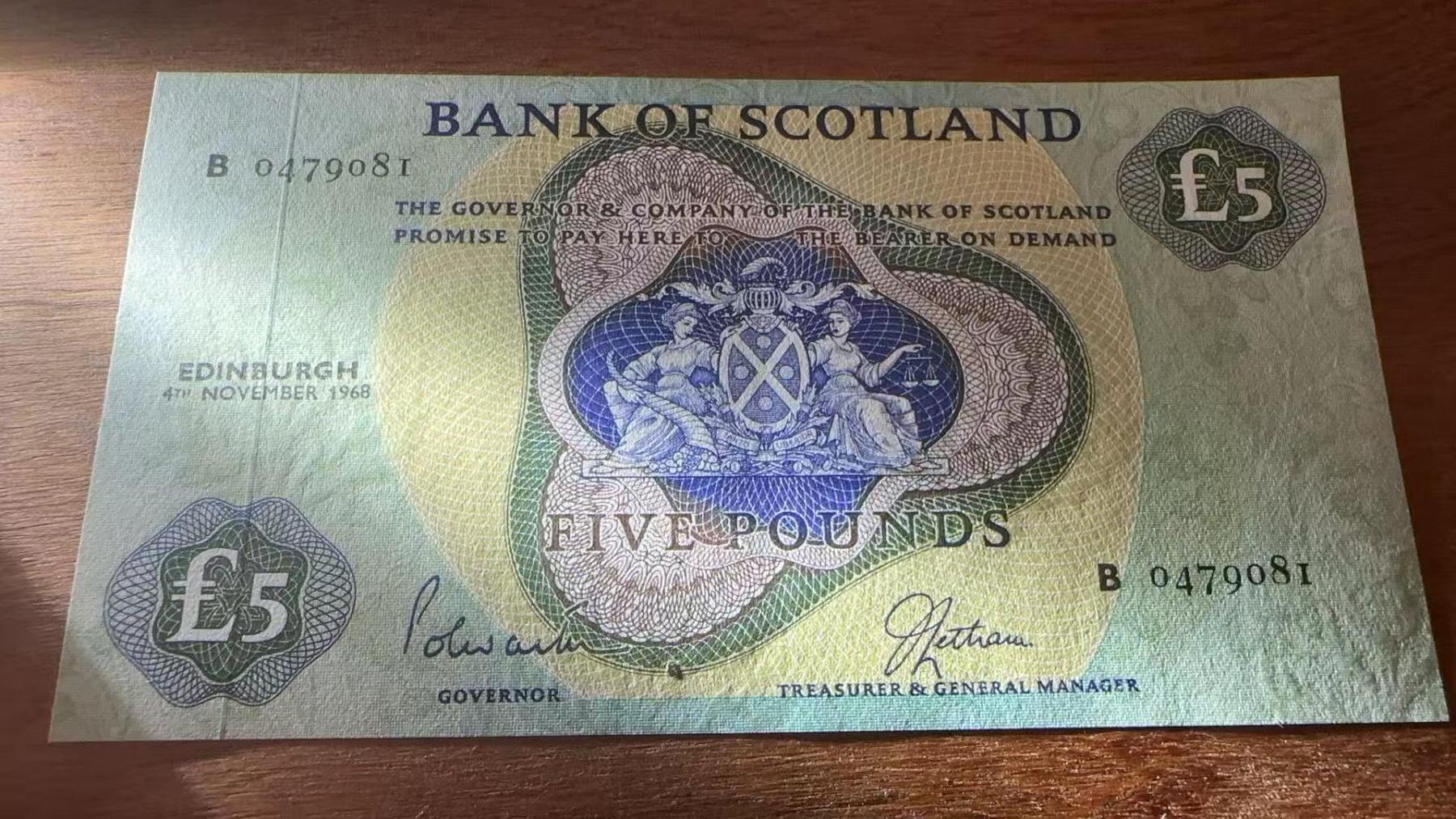 徐霞客拍卖首拍 苏格兰/苏格兰银行	P-110a 1968年5镑	UNC- B0479081 有个黑痣	中央的苏格兰纹章由象征繁荣的丰饶角与代表正义的天平构成，两侧守护女神的设计融合了苏格兰的历史叙事与金融传统。币面保留了“PROMISE TO PAY TO THE BEARER ON DEMAND”这一19世纪银行券的传统表述，它是英国纸币从可兑换黄金到信用货币演变的活化石，这种表述在现代纸币中已极为罕见。	