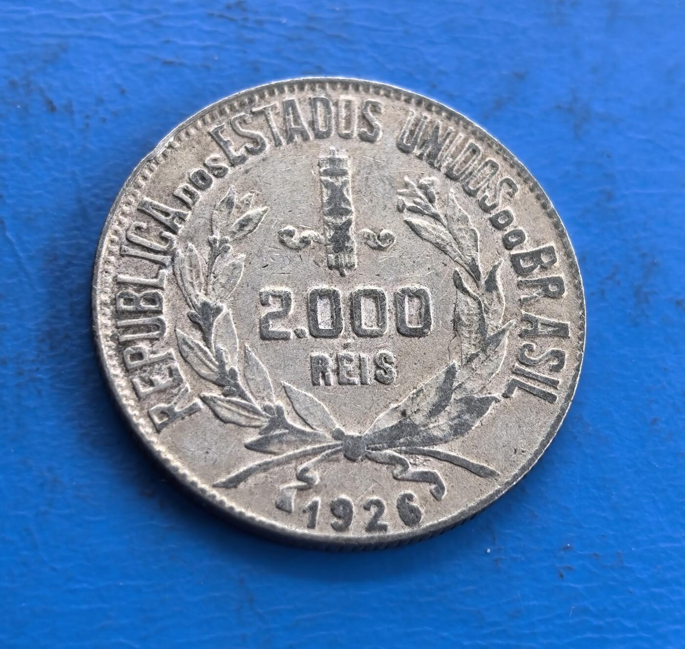 外国优质老铜币高银银币，周六九点倒数截拍，满百包邮，持续收拍 巴西1926 年 2000 瑞斯银币，正面自由女神头像柔美，橄榄枝点缀发丝，外圈星纹环绕，雕刻细腻传神；背面国名与月桂枝环绕面值，纹饰对称规整，线条简洁流畅，金属质感古朴，尽显南美钱币的经典美学与工艺质感。