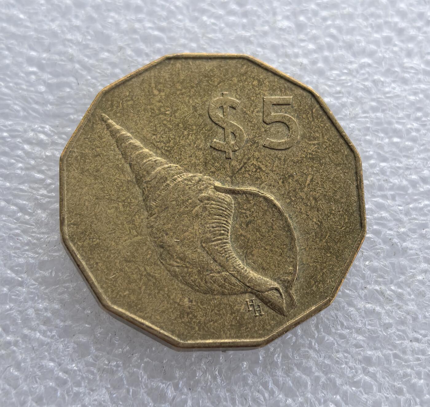 外国优质老铜币高银银币，周六九点倒数截拍，满百包邮，持续收拍 库克群岛1988 年5 元黄铜纪念 / 流通币，采用十二边形独特形制。正面为伊丽莎白二世头像，标注 “COOK ISLANDS” 与年份；背面铸海螺图案及面值 $5，海螺是南太平洋地域象征，属英联邦海外领地特色钱币。