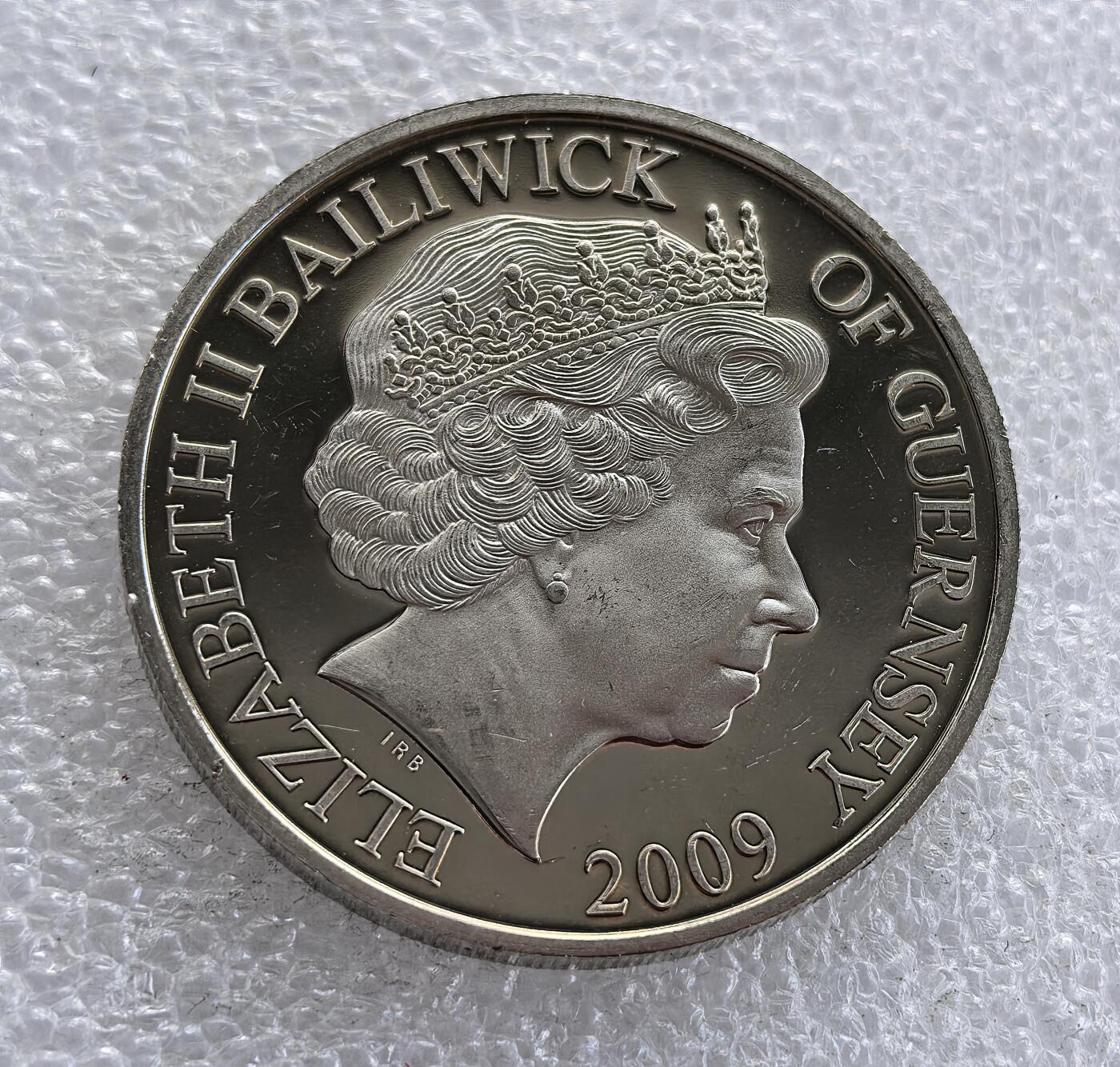 外国优质老铜币高银银币，周六九点倒数截拍，满百包邮，持续收拍 英属根西行政区2009 年 5 镑纪念币，主题为海军航空维多利亚十字勋章（Naval Aviation Victoria Crosses）。正面铸伊丽莎白二世头像与属地标识，背面刻画海军航空英雄群像，配维多利亚十字勋章与 “FLY NAVY” 标识，致敬海军航空领域获最高军功章的英雄，属英联邦军事主题经典纪念币。