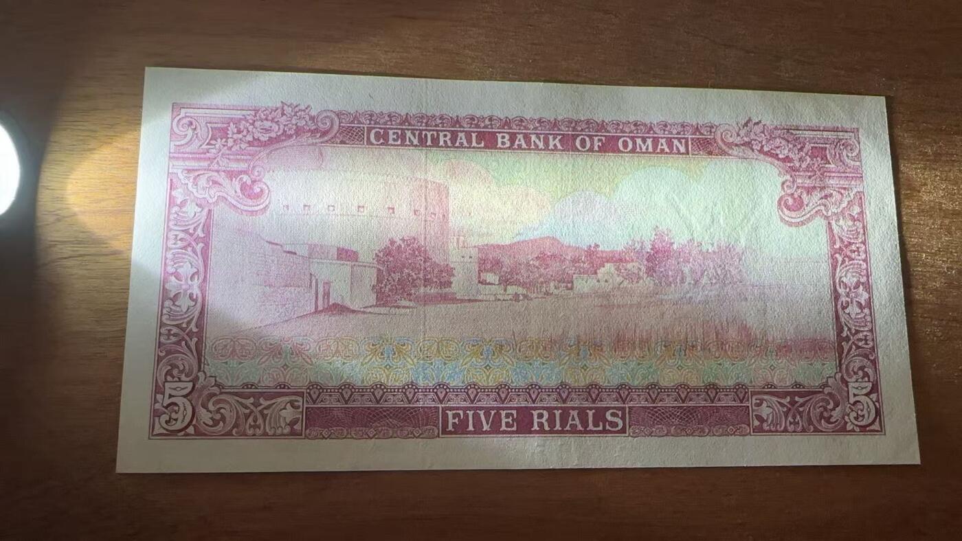 徐霞客拍卖首拍 阿曼	P-18a 1977年5里亚尔 A/4 004880	unc-	阿曼苏丹国5里亚尔纸币 正面以阿拉伯书法标注面额，配阿曼国徽核心双剑纹章，彰显王室权威与伊斯兰属性。 发行于阿曼现代化建设初期，见证该国从传统经济向油气经济转型。 背面为清真寺图案，呼应伊斯兰宗教核心地位。 币面融合阿拉伯书法艺术与伊斯兰纹样设计，采用红、蓝、金三色套印工艺。		
