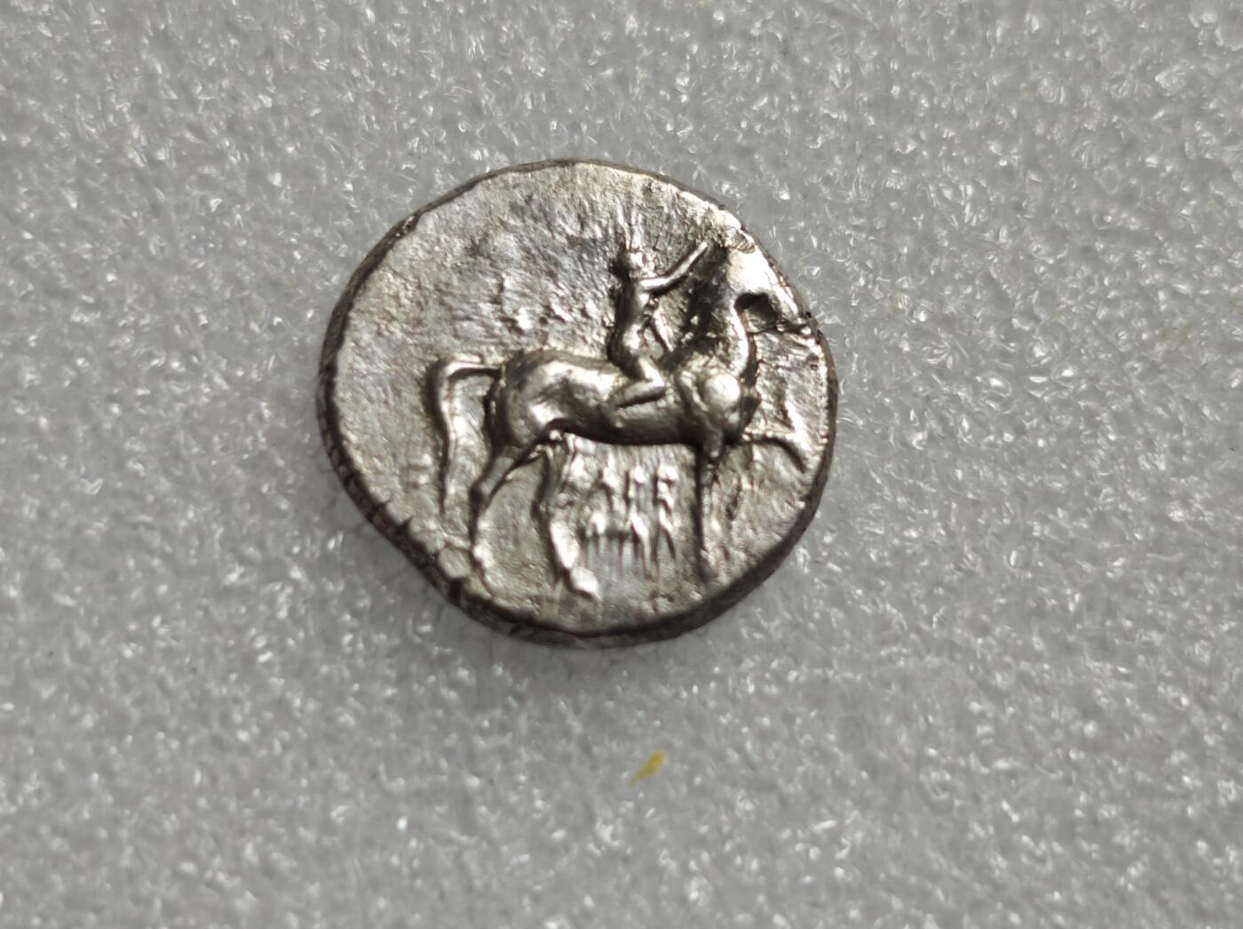 瓶子🏺第227期拍卖会  古希腊时期卡拉布里亚地区（大希腊）塔兰托（Tarent）铸造的迪德拉克马银币，铸造时间大约在公元前390年至380年  钱币的正面图案为一名青年骑在马上  背面图案为塔兰托的守护神塔拉斯（Taras）骑在海豚上 好品版本稀少  塔拉斯手持圣器三足祭坛 