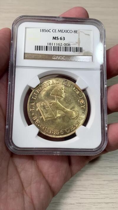 万国钱币拍卖第060期（万国六十期纪念大拍） NGC MS63 1856C CE墨西哥金鹰8埃斯库多大金币 库利亚坎造币厂铸造 墨西哥鹰金质化后的观感令人爱不释手 极其经典的手持自由帽与宪法设计 原始黄金丝绸转光 极其优异的打制 鹰羽根根可数 NGC老盒顶级典藏状态