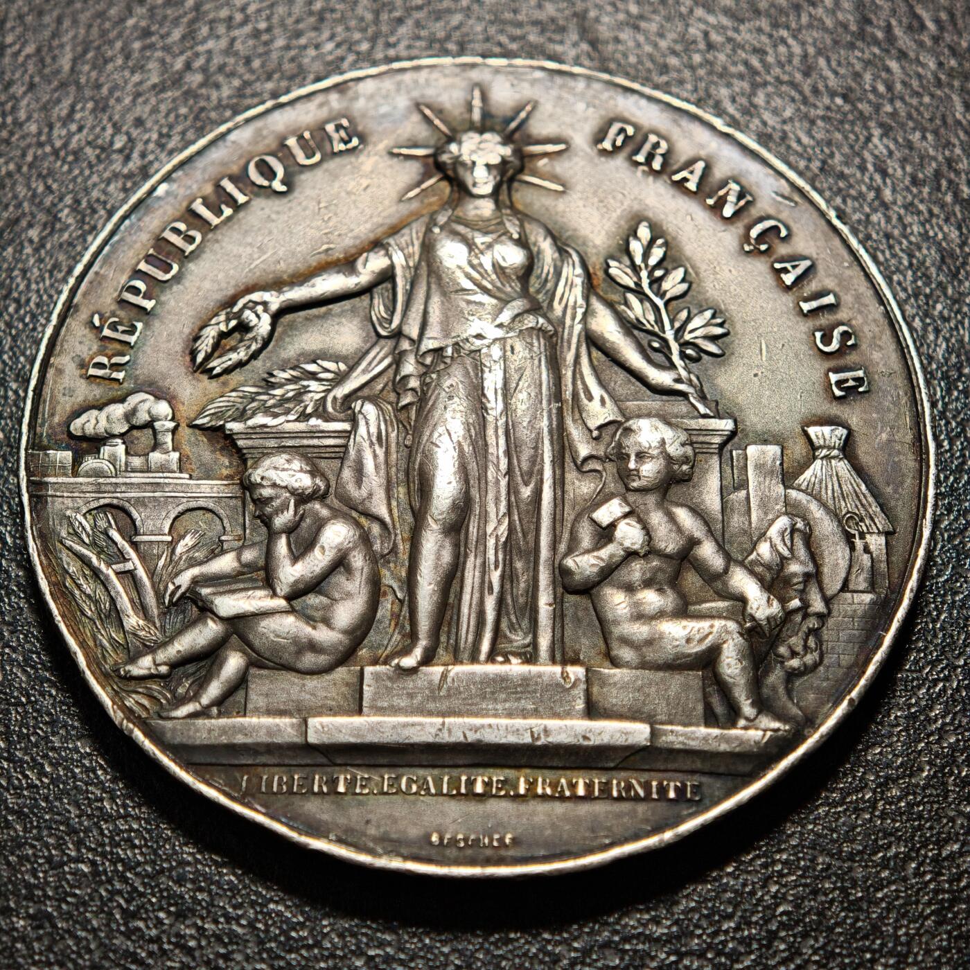 【德藏】世界币章拍卖第163期（拍品征集中~欢迎藏友联系） 1908年 法兰西勒瓦卢瓦-佩雷理工协会自由、平等、博爱大银章 正面是头戴光芒四射的冠冕、手持麦穗与橄榄枝的‌玛丽安娜站立形象和两位小天使，背面是背面是橄榄枝交叉形成的花环和文字，少见品种 直径约：50.8mm；重约：60.5g
