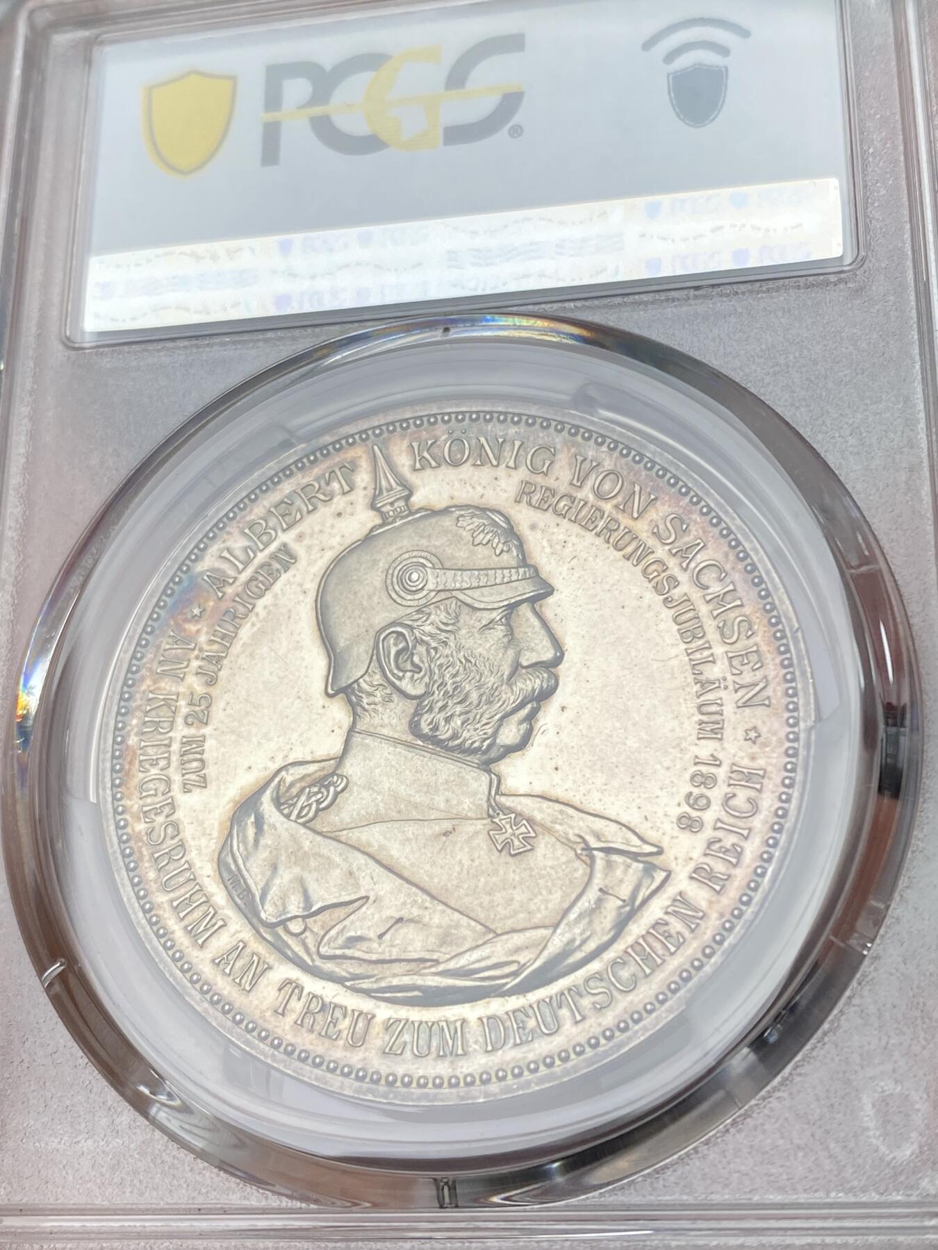 万国钱币拍卖第060期（万国六十期纪念大拍） PCGS SP64 1898年德国萨克森国王阿尔伯特金禧纪念银章 御极二十五周年 唯一记录冠军分 强镜面喷砂精铸，PP模具高浮雕，人物雕刻极其精细，栩栩如生。光边。少见品种。正面:萨克森公爵阿尔伯特半身像，头戴红色公爵圆帽，胸口挂着金羊毛勋章。他创立了韦廷家族的阿尔伯特支系。背面:萨克森国王阿尔伯特戎装半身像，身着大元帅服，头戴普鲁士元帅尖顶盔，佩戴大铁十字勋章。精工细作，实物极其漂亮。