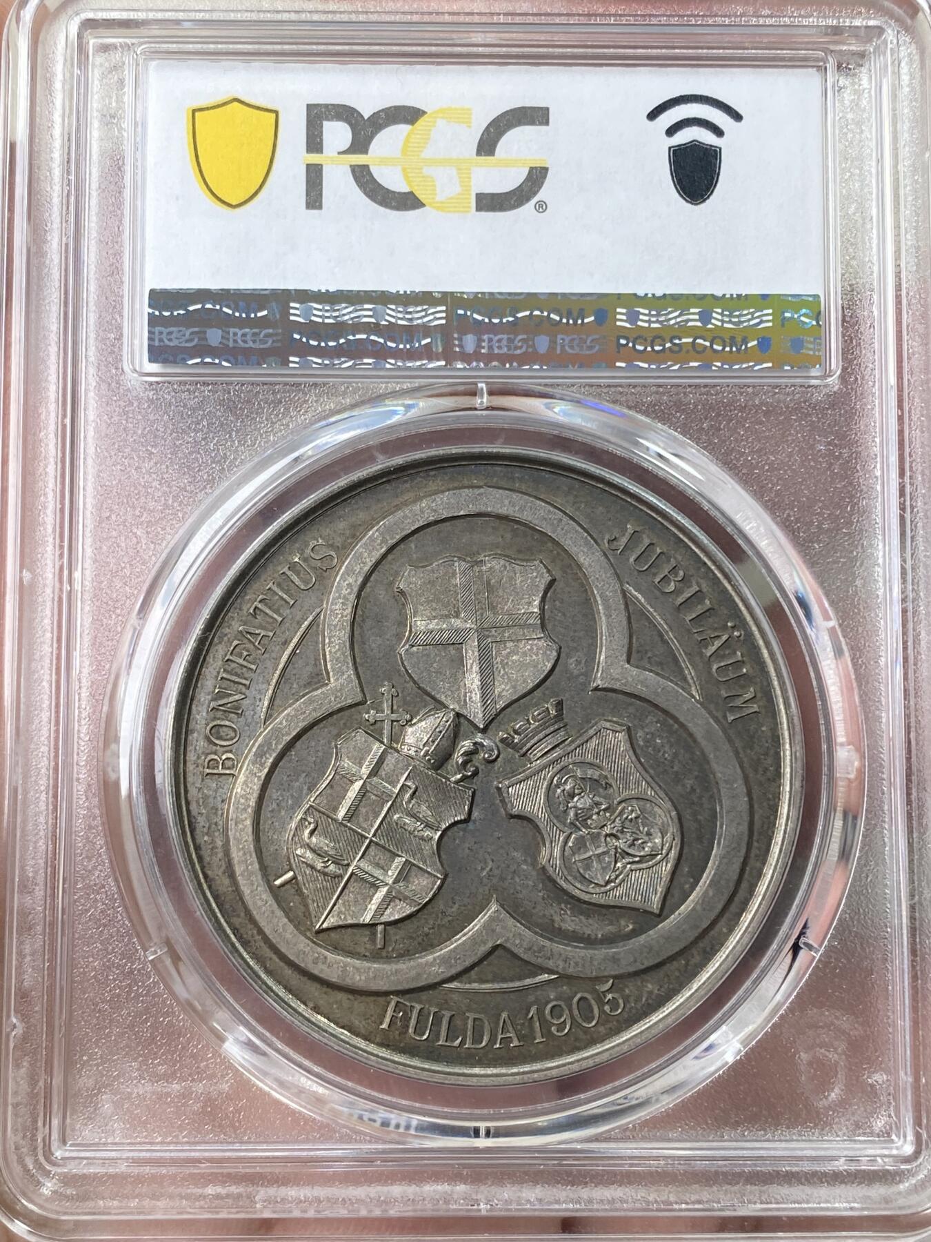 万国钱币拍卖第060期（万国六十期纪念大拍） PCGS MS65 1905年德国黑森富尔达圣博尼法斯逝世1150年纪念银章 稀有品种 唯一评级记录冠军分 浮雕精铸，百年纸袋彩浆。正面:圣博尼法斯全身像，右手举着十字架，左手拿着传道权杖，日耳曼尼亚的守护神。朱庇特万神之王圣橡树被砍倒后发出了新芽。背面:三叶草圈环内的三面盾徽。朱庇特万神之王橡树是日耳曼教徒的一棵圣树。圣树受到日耳曼各民族的广泛崇敬，其木材被用来在圣彼得教堂的原址建造教堂。