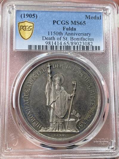 万国钱币拍卖第060期（万国六十期纪念大拍） - PCGS MS65 1905年德国黑森富尔达圣博尼法斯逝世1150年纪念银章 稀有品种 唯一评级记录冠军分 浮雕精铸，百年纸袋彩浆。正面:圣博尼法斯全身像，右手举着十字架，左手拿着传道权杖，日耳曼尼亚的守护神。朱庇特万神之王圣橡树被砍倒后发出了新芽。背面:三叶草圈环内的三面盾徽。朱庇特万神之王橡树是日耳曼教徒的一棵圣树。圣树受到日耳曼各民族的广泛崇敬，其木材被用来在圣彼得教堂的原址建造教堂。