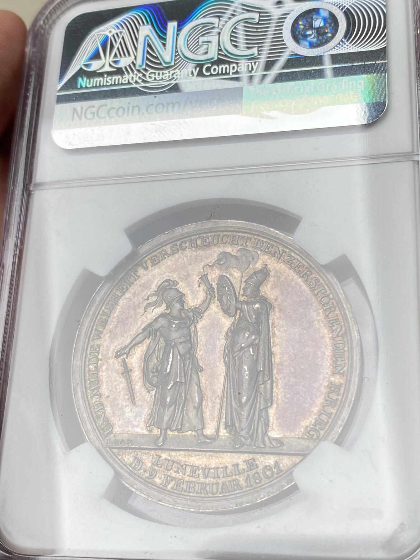 万国钱币拍卖第060期（万国六十期纪念大拍） NGC MS61 1801年德国吕内维尔和平纪念银章 罕见品种 和平女神站在云朵前的地球之上 背面密涅瓦女神向贝洛娜女神伸出埃癸斯盾 贝洛娜女神随即放下了手中剑 彩虹色极美均匀包浆高浮雕收藏品质