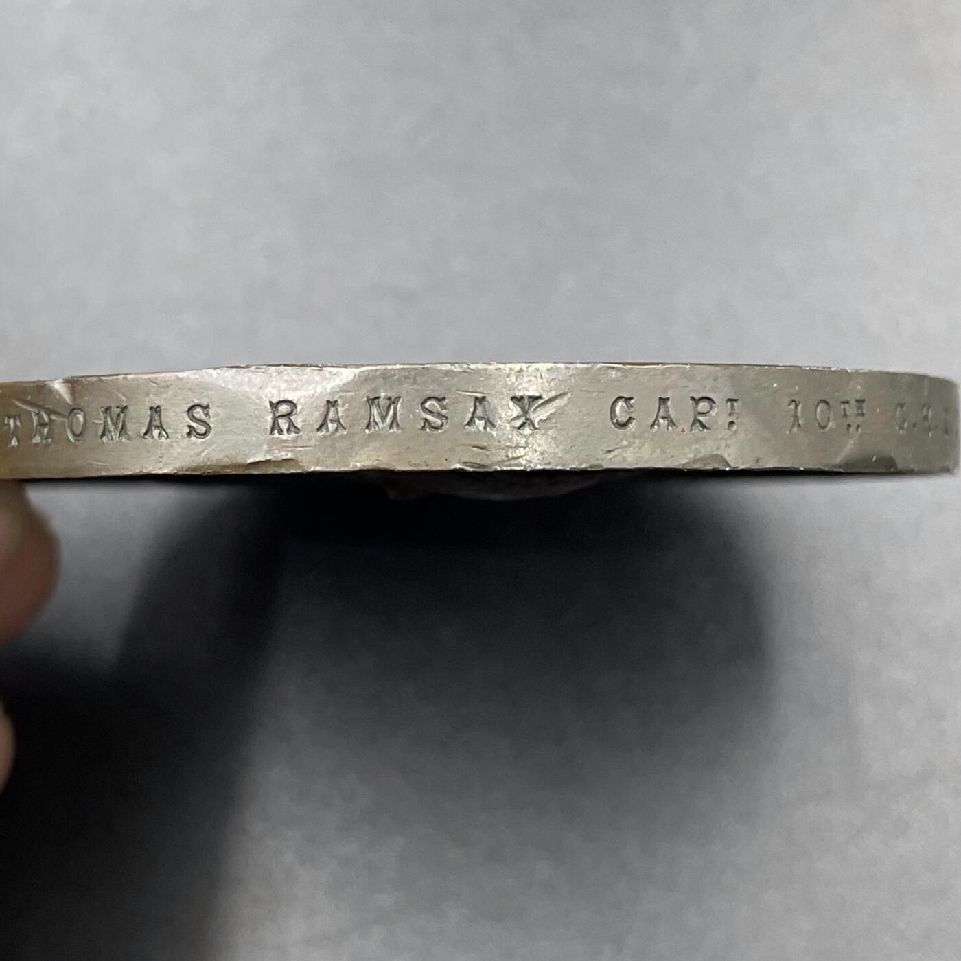 「木头集藏」章牌专场-第67场 1881年英国志愿兵运动21周年纪念铜章，直径：63.5mm，93.8 g，中央刻画天使长米迦勒（St. Michael），他身披盔甲、手持盾牌与宝剑，象征着守护与勇气。左侧是怀抱孩子的母亲与少女，手持橄榄枝，代表家园与和平；右侧是跪姿的志愿兵与列队士兵，背景还有帆船，呼应了志愿兵海陆防御的职责。