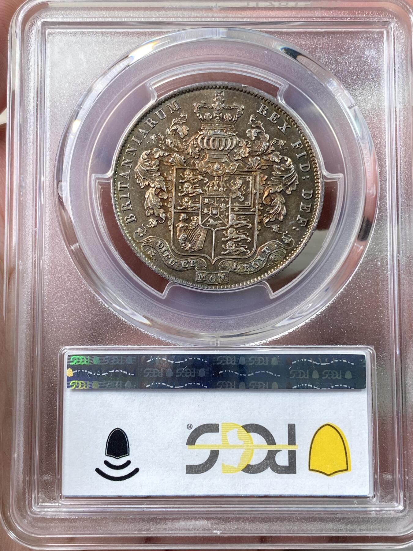 万国钱币拍卖第060期（万国六十期纪念大拍） PCGS MS64 1826年英国乔治四世国王1/2克朗银币 ESC显示1826比1825要略少一些，正反双面留下在纸袋中孕育而出的英伦五彩，赭褐色包浆在边缘流转成了紫罗兰与靛青。乔治四世以其出众的艺术品味闻名于英国上流社会，他钦点用于币面的头像有着非同一般的艺术造诣。