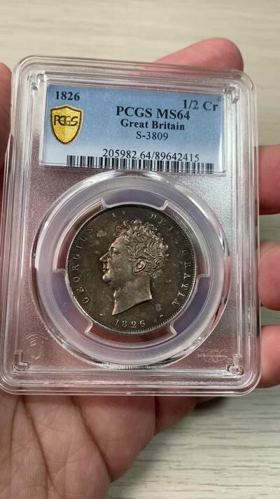 万国钱币拍卖第060期（万国六十期纪念大拍） PCGS MS64 1826年英国乔治四世国王1/2克朗银币 ESC显示1826比1825要略少一些，正反双面留下在纸袋中孕育而出的英伦五彩，赭褐色包浆在边缘流转成了紫罗兰与靛青。乔治四世以其出众的艺术品味闻名于英国上流社会，他钦点用于币面的头像有着非同一般的艺术造诣。