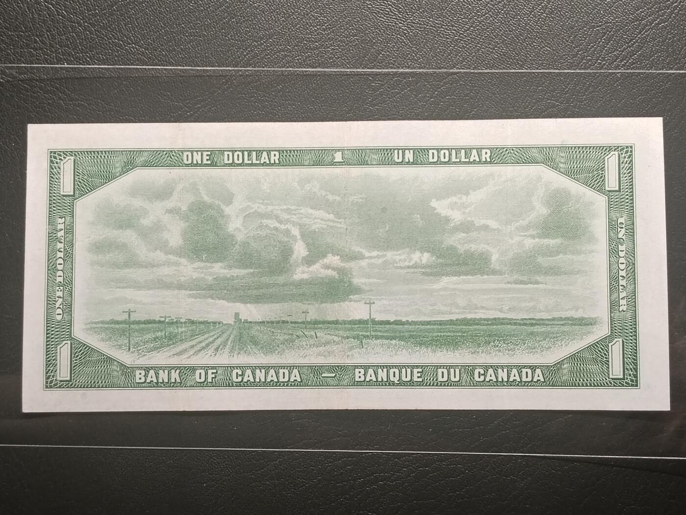 2026二月第一期，总215期 加拿大1954版1元“魔鬼脸”版本首签AUNC有微裂，因新发行纸币的女王发型可以看出来一个魔鬼向下看的脸而被舆论攻击，从而紧急改版，导致此版本稀少