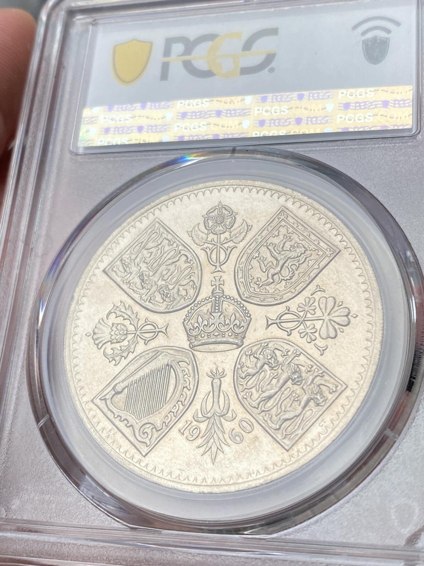 万国钱币拍卖第060期（万国六十期纪念大拍） PCGS PR64DCAM 1960英国伊丽莎白二世V.I.P精制克朗 VIP精制是20世纪英国币收藏中的一个重要系列，其中的克朗主币更是备受追捧。仅铸造用于馈赠王室贵族及政府高官，使用与普通精制不同的特殊工艺模具，盾徽带有迷人的喷砂霜感。发行量极度稀少，ESC目录标注稀有度为R3，其总存世量应该在百枚以内。国内首次公开上拍品种，各位藏家把握机会。