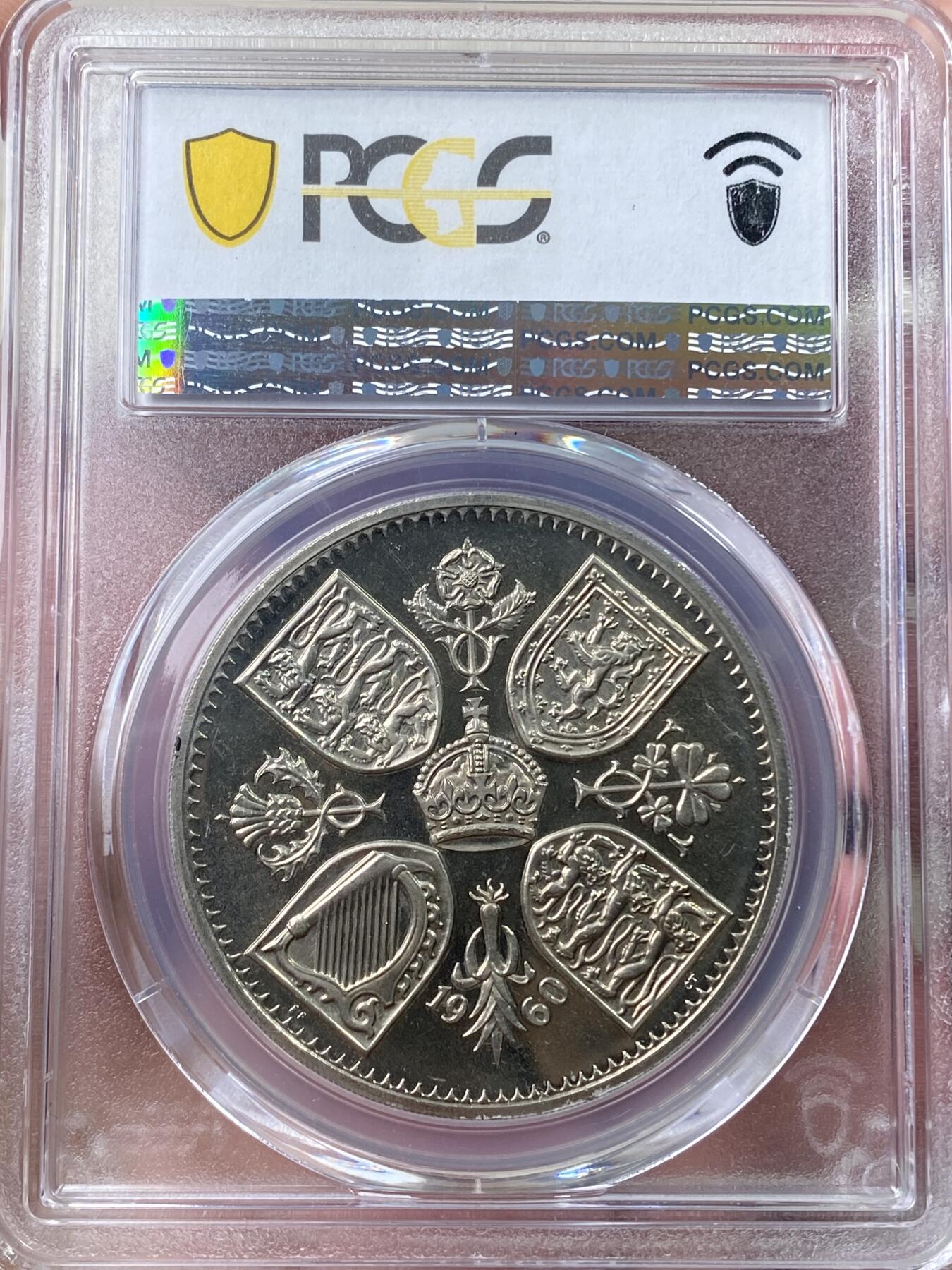 万国钱币拍卖第060期（万国六十期纪念大拍） PCGS PR64DCAM 1960英国伊丽莎白二世V.I.P精制克朗 VIP精制是20世纪英国币收藏中的一个重要系列，其中的克朗主币更是备受追捧。仅铸造用于馈赠王室贵族及政府高官，使用与普通精制不同的特殊工艺模具，盾徽带有迷人的喷砂霜感。发行量极度稀少，ESC目录标注稀有度为R3，其总存世量应该在百枚以内。国内首次公开上拍品种，各位藏家把握机会。