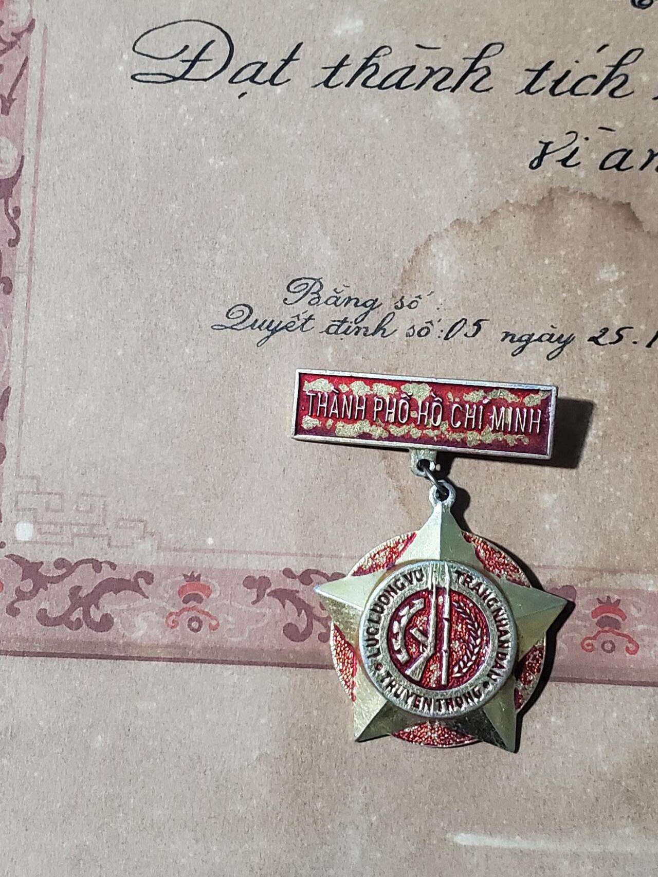 韵星假日军品类拍卖第三十九期暨默多克中校夫妇专场 -- Rimey Holidays Militaria Auction 39 & The Modoks Collection  越南社会主义共和国为胡志明市守备（公安，国安，军队）奖章+为公安长期优秀服务奖状一张 少见老纸张 后采用铜版纸印刷 章品相好