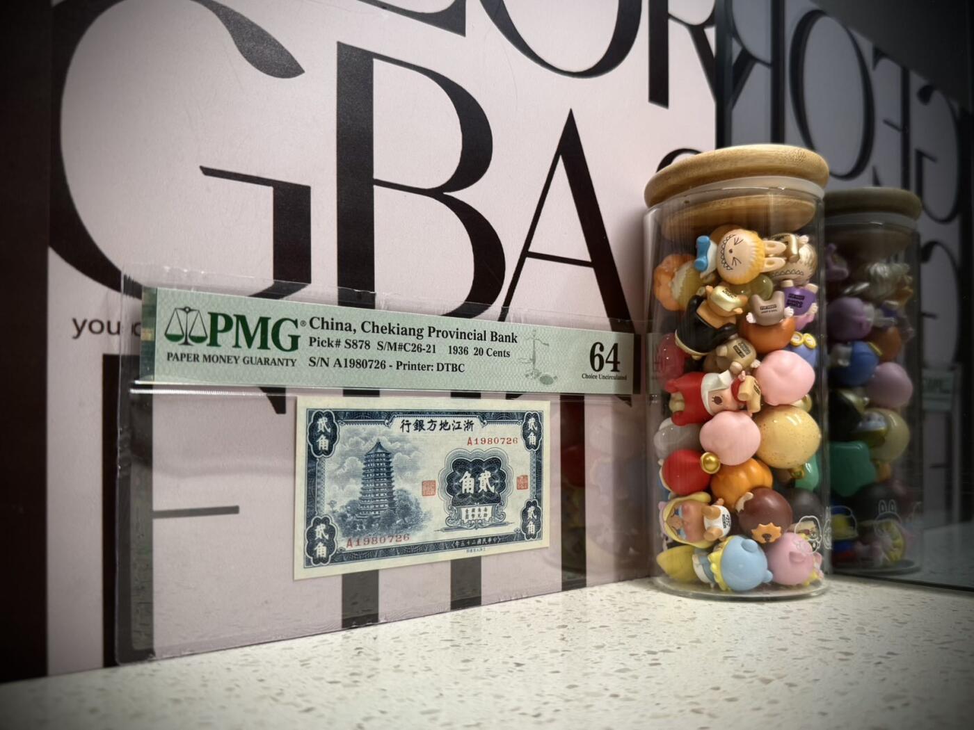 （自动截拍）PMG评级民国纸币专拍第20260206期，全场包邮  【乾奕收藏】出民国25年1936年浙江地方银行大东版贰角一枚，正面雷峰塔图案，美国PMG64分，1980-7-26生日号靓号，比较难出