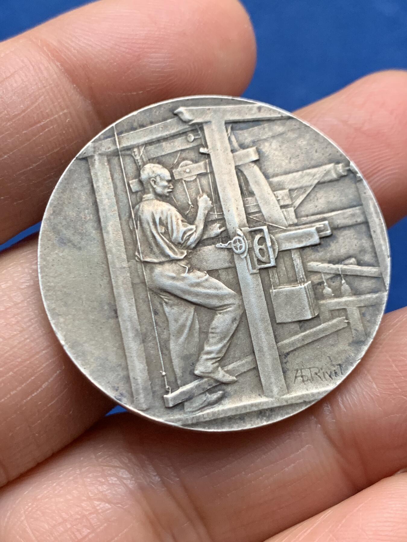 《竞宝斋》第463-465场 周日，周一，周二，3场连拍 （全场包邮）欢迎送拍 法兰西纺织总协会银质奖章，银章本体大约铸造于20世纪初期，此枚无加刻颁奖年版，推测授奖颁发时段在1900-1940年间，中央饰框内刻有得奖者名称“Mr Fenoyer/费诺耶先生”，  雕刻师：A. RIVET阿道夫·里韦，边缘ARGENT 950银标/丰饶角。重约20.6克。