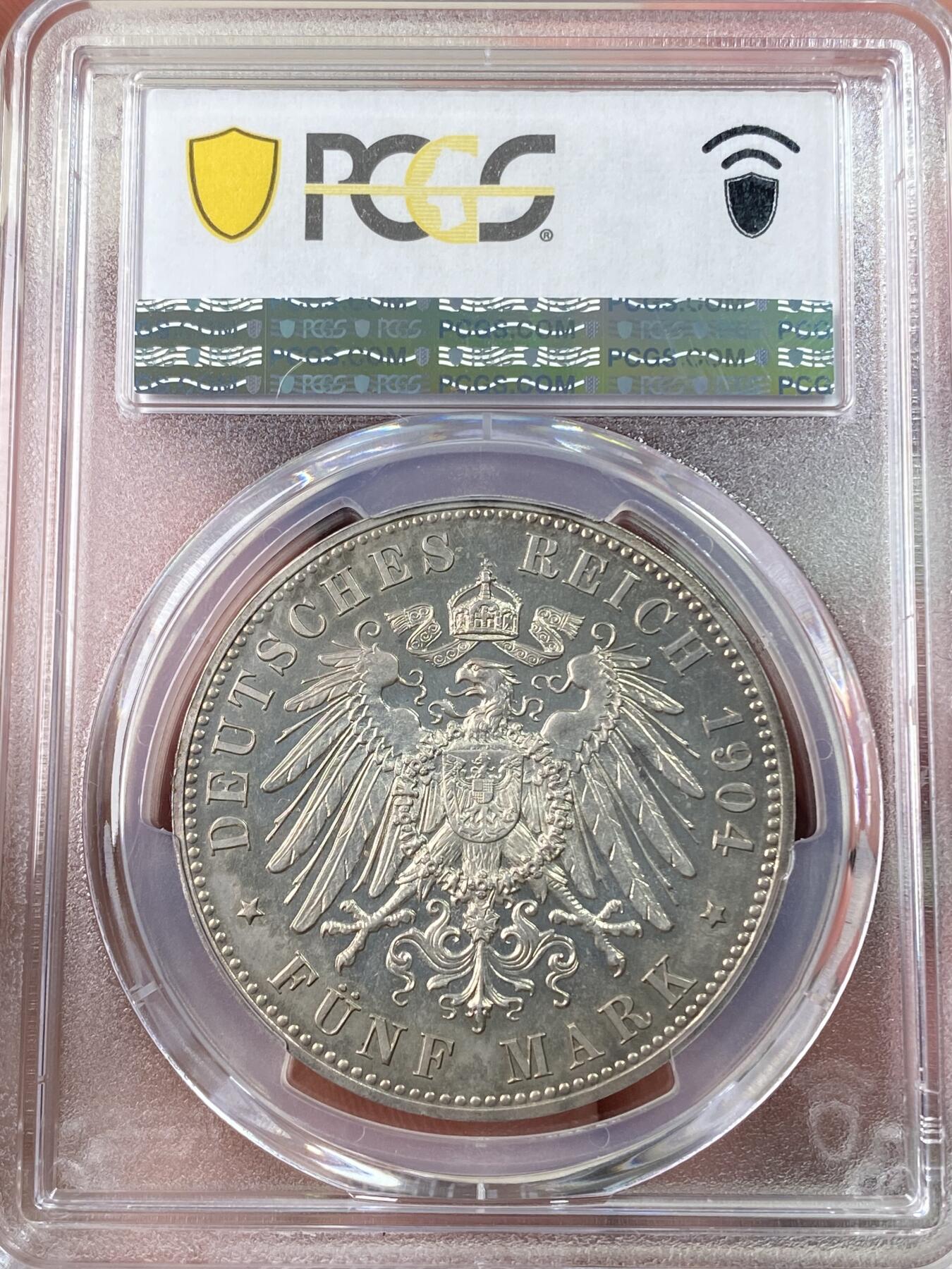 万国钱币拍卖第060期（万国六十期纪念大拍） PCGS PR64 1904德国梅克伦堡-什未林皇家大婚精制纪念5马克 用以纪念弗里德里希·弗朗茨四世与汉诺威及坎伯兰的亚历山德拉公主的婚礼，发行量仅2500枚。耀眼的香槟色包浆如水彩般铺展于深度镜面的底板 顶级德式工艺 令人赏心悦目的收藏级品质