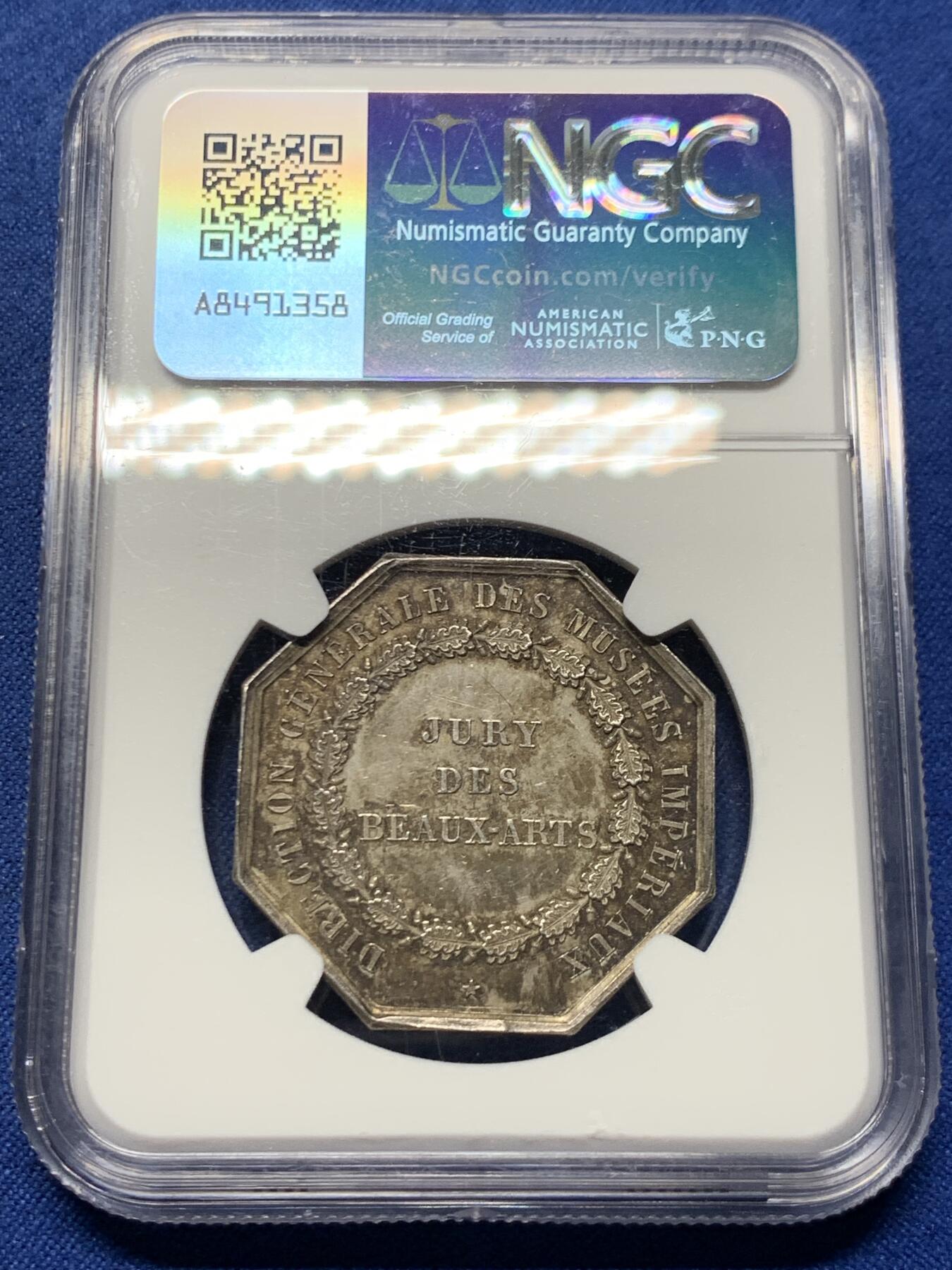 《竞宝斋》第463-465场 周日，周一，周二，3场连拍 （全场包邮）欢迎送拍 NGC MS63 帝国博物馆艺术评审团（Art Jury of Imperial Museum）银质八角代币，正面中央为帝国鹰徽，鹰立于盾徽之上，盾徽外覆披风并加冕皇冠，周围辅以勋章、绶带与权杖元素，构成完整的帝国象征体。