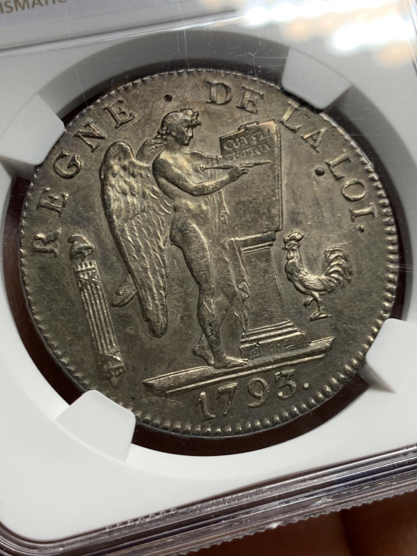 《竞宝斋》第463-465场 周日，周一，周二，3场连拍 （全场包邮）欢迎送拍 热门品种 NGC AU 法国国民公会时期1793年6里弗尔，天使埃居，品相好打制清晰，几乎没有流通磨损，状态很自然。铸造于国民公会时期(1792年9月21日-1795年10月26日)，持续时间很短，留存好品很少，此时路易十六已被斩首，因此正面由站立天使取代路易十六的头像，1793年为共和二年ANlI。天使顶上有一小凹，细节见图。