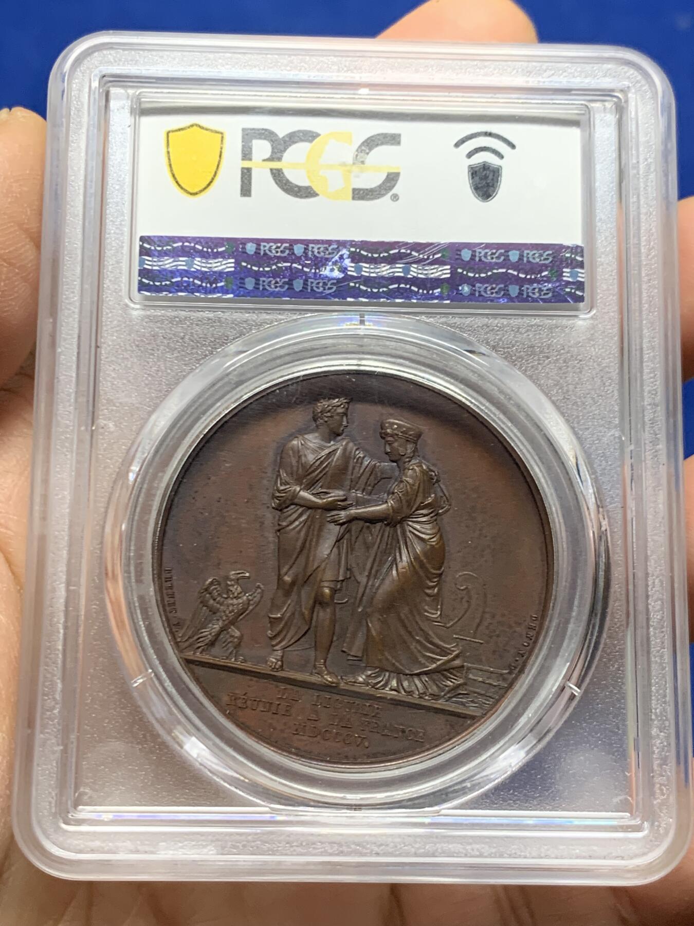 《竞宝斋》第463-465场 周日，周一，周二，3场连拍 （全场包邮）欢迎送拍 PCGS SP64 亚军分 法国1805年拿破仑一世吞并利古里亚原铸铜章 巴黎造币厂 巧克力包浆 左边拿破仑身穿古罗马元老院服饰cos凯撒，接受右边着罗马将军长袍的利古里亚首领低头屈服，两侧饰有象征性的鹰和船头，记录着拿皇攻城略地的丰功伟绩，衣服缕缕毕现生动刻画，人像稀少品种，加厚盒，标签可晃动。仅一枚更高分
