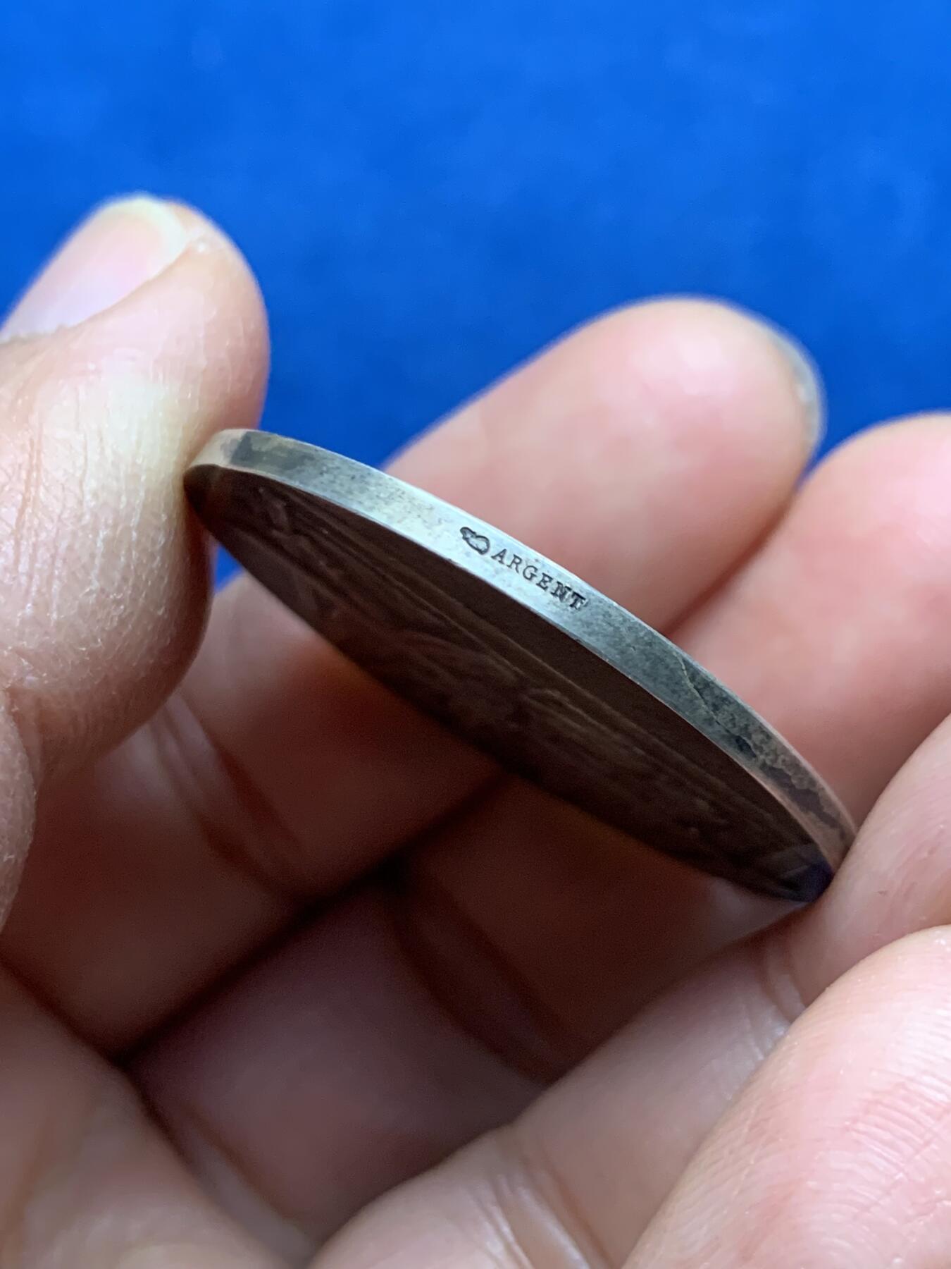 《竞宝斋》第463-465场 周日，周一，周二，3场连拍 （全场包邮）欢迎送拍 法兰西纺织总协会银质奖章，银章本体大约铸造于20世纪初期，此枚无加刻颁奖年版，推测授奖颁发时段在1900-1940年间，中央饰框内刻有得奖者名称“Mr Fenoyer/费诺耶先生”，  雕刻师：A. RIVET阿道夫·里韦，边缘ARGENT 950银标/丰饶角。重约20.6克。