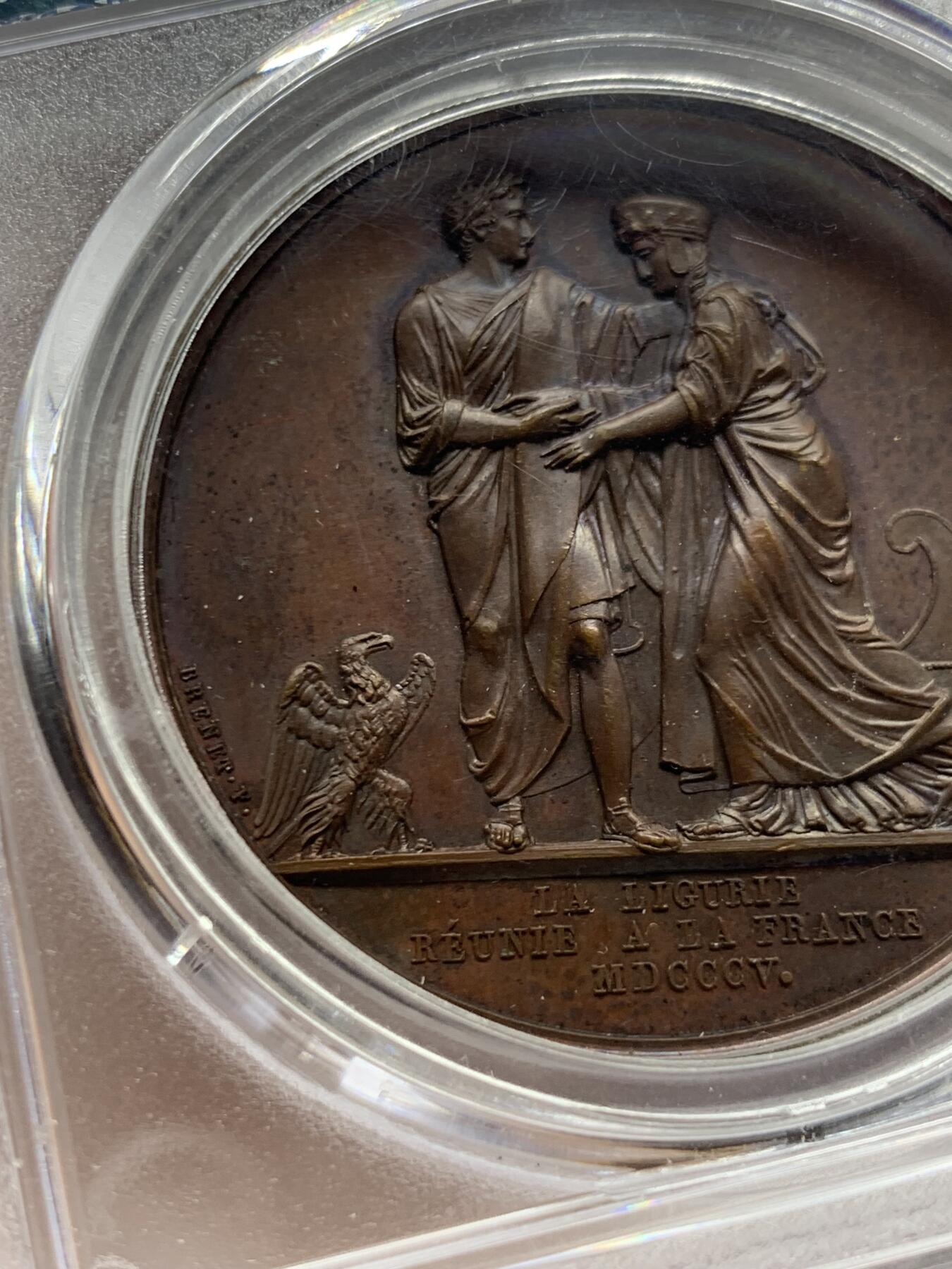 《竞宝斋》第463-465场 周日，周一，周二，3场连拍 （全场包邮）欢迎送拍 PCGS SP64 亚军分 法国1805年拿破仑一世吞并利古里亚原铸铜章 巴黎造币厂 巧克力包浆 左边拿破仑身穿古罗马元老院服饰cos凯撒，接受右边着罗马将军长袍的利古里亚首领低头屈服，两侧饰有象征性的鹰和船头，记录着拿皇攻城略地的丰功伟绩，衣服缕缕毕现生动刻画，人像稀少品种，加厚盒，标签可晃动。仅一枚更高分