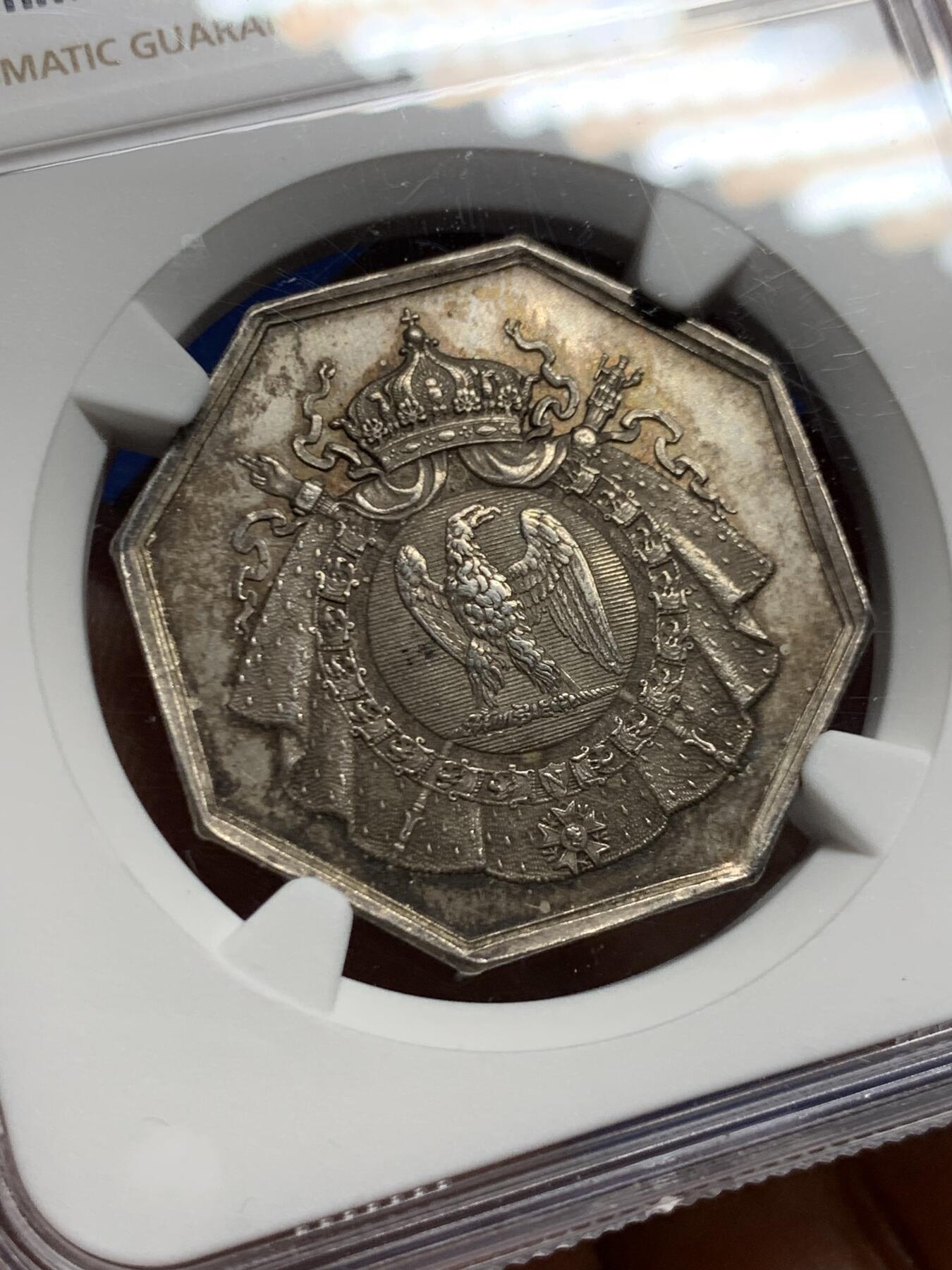 《竞宝斋》第463-465场 周日，周一，周二，3场连拍 （全场包邮）欢迎送拍 NGC MS63 帝国博物馆艺术评审团（Art Jury of Imperial Museum）银质八角代币，正面中央为帝国鹰徽，鹰立于盾徽之上，盾徽外覆披风并加冕皇冠，周围辅以勋章、绶带与权杖元素，构成完整的帝国象征体。