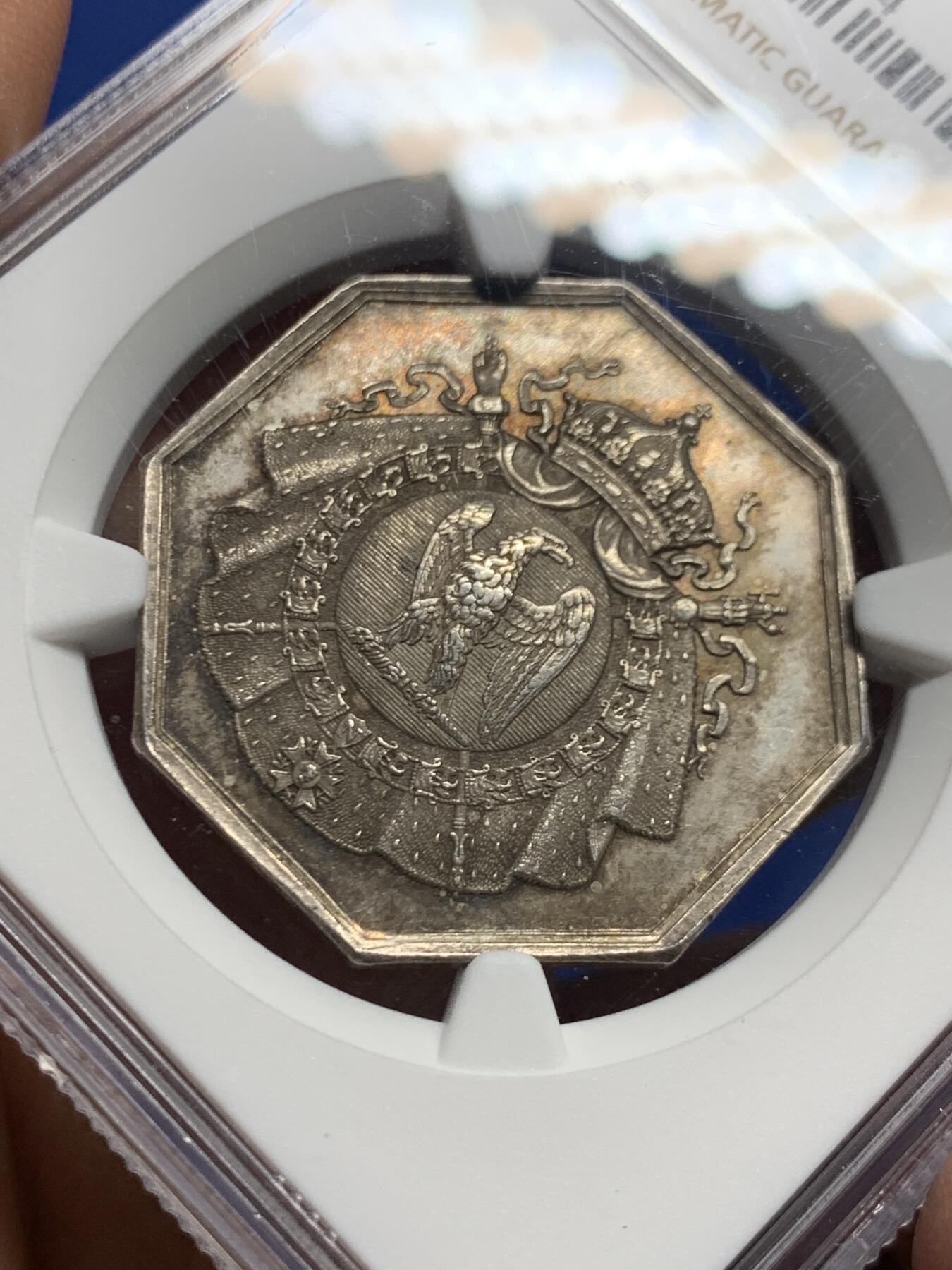 《竞宝斋》第463-465场 周日，周一，周二，3场连拍 （全场包邮）欢迎送拍 NGC MS63 帝国博物馆艺术评审团（Art Jury of Imperial Museum）银质八角代币，正面中央为帝国鹰徽，鹰立于盾徽之上，盾徽外覆披风并加冕皇冠，周围辅以勋章、绶带与权杖元素，构成完整的帝国象征体。