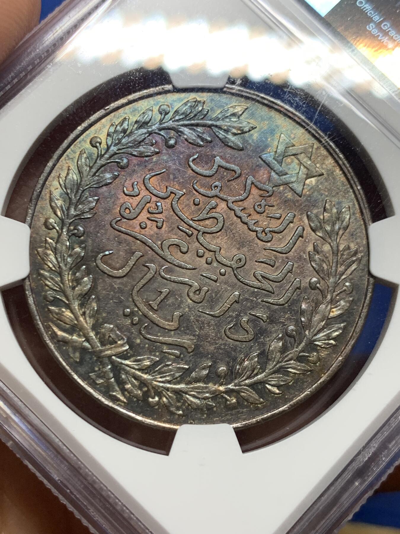 《竞宝斋》第463-465场 周日，周一，周二，3场连拍 （全场包邮）欢迎送拍 NGC MS62 摩洛哥1911六芒星1里亚尔大银币 巴黎厂铸 少见北非主币大银且双面绚丽深五彩 如此漂亮的顶级五彩不容错过