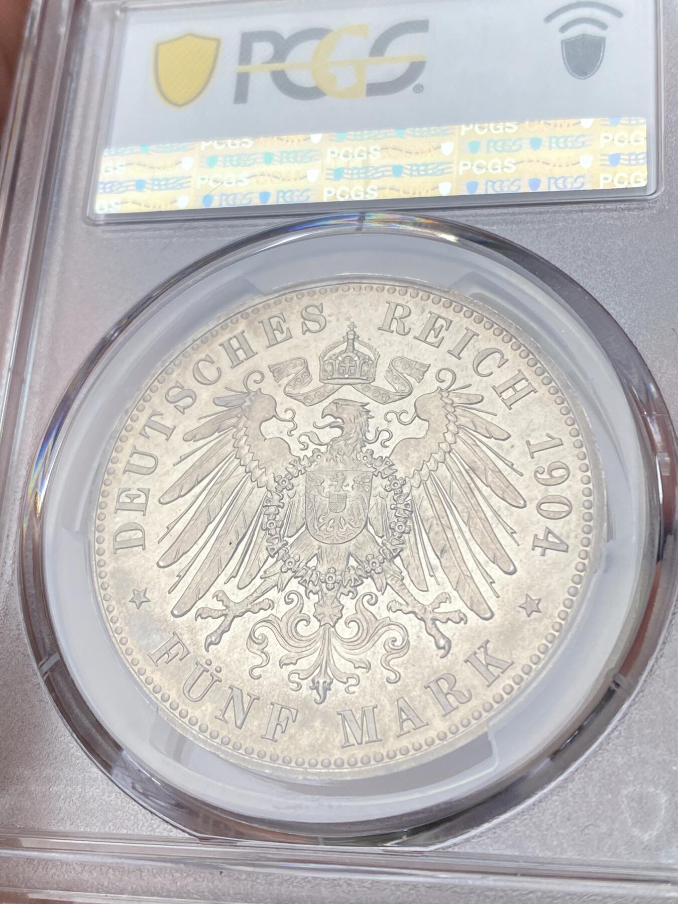万国钱币拍卖第060期（万国六十期纪念大拍） PCGS PR64 1904德国梅克伦堡-什未林皇家大婚精制纪念5马克 用以纪念弗里德里希·弗朗茨四世与汉诺威及坎伯兰的亚历山德拉公主的婚礼，发行量仅2500枚。耀眼的香槟色包浆如水彩般铺展于深度镜面的底板 顶级德式工艺 令人赏心悦目的收藏级品质