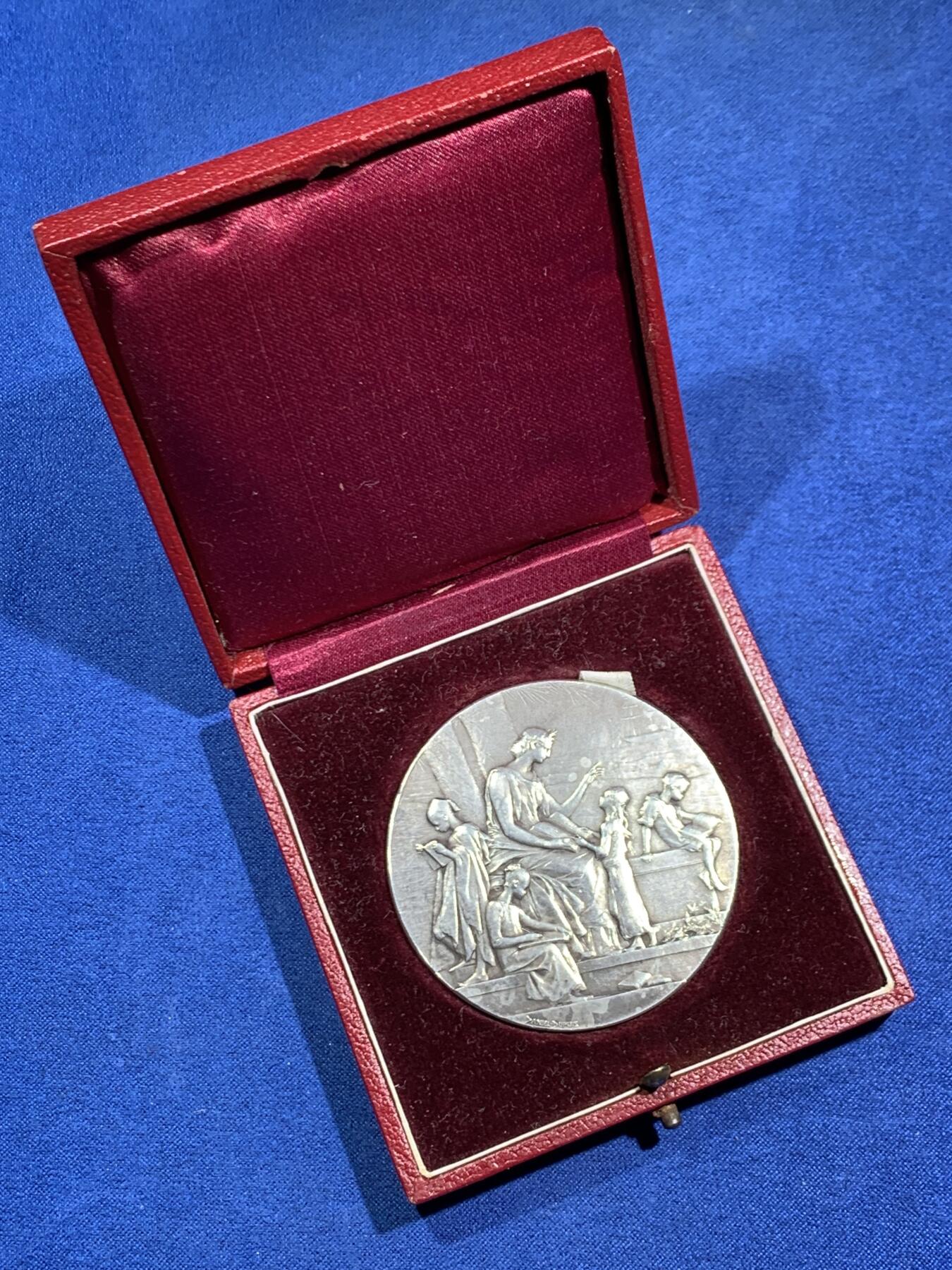 《竞宝斋》第464场 周日，周一，周二，3场连拍 （全场包邮）欢迎送拍 法国新艺术章牌雕刻大师杜普伊D.Dupuis作品，法语联盟奖章，法国的象征玛丽安娜女神，在月桂树下教美澳亚非四大洲的孩子读书，写实浅浮雕精品。小小的章面上，能把四大洲孩子的衣着甚至面部特色都生动表现出来，绝对是大师级雕刻功力，材质950银，边铭丰饶角argent，直径50mm，重量66g，品相很好，包浆有轻微白斑，自藏佳品