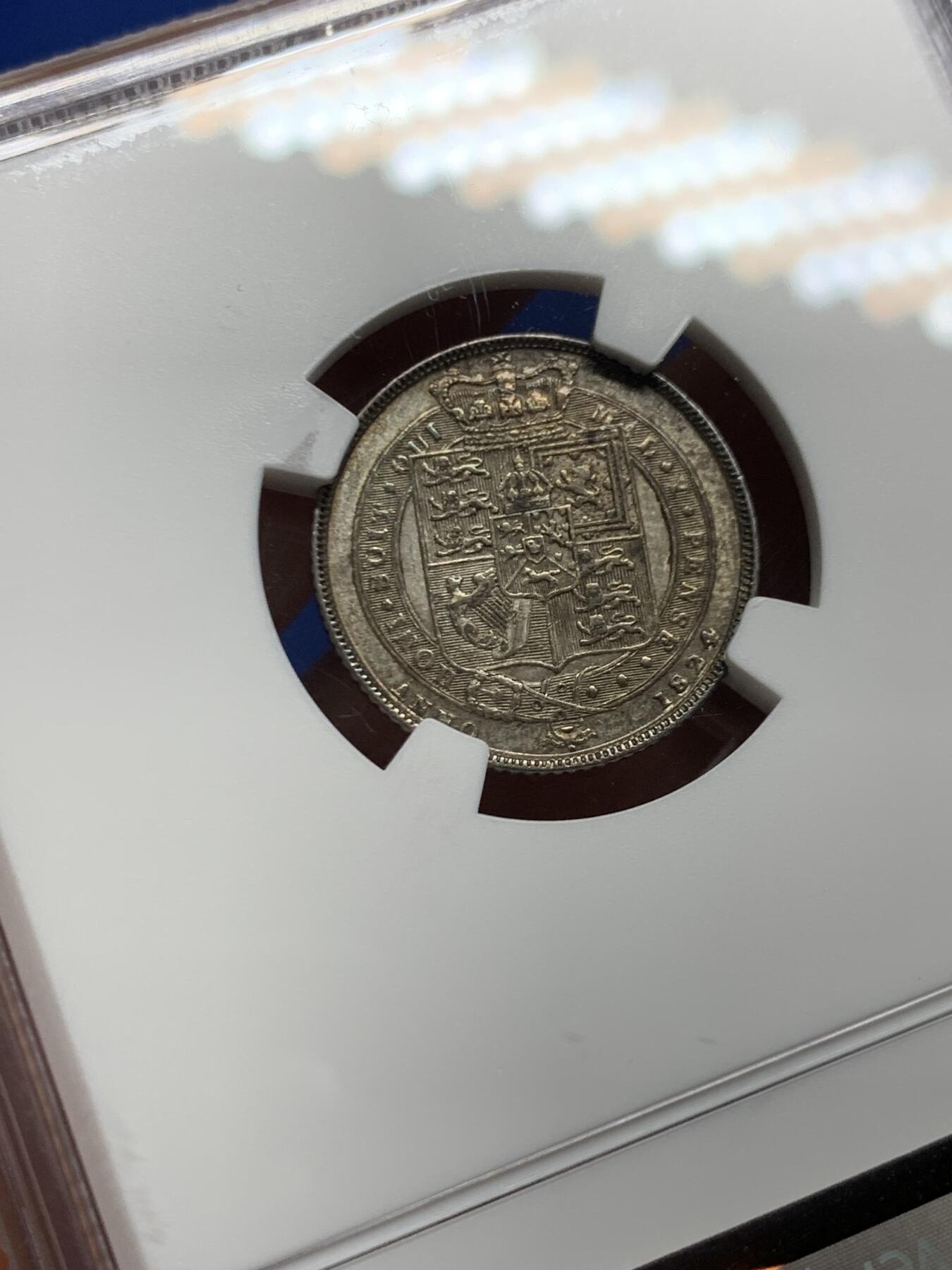 《竞宝斋》第464场 周日，周一，周二，3场连拍 （全场包邮）欢迎送拍 NGC MS62 英国1824年乔治四世国王6便士银币，铸造于英国皇家造币厂，正面有明显的镜面感以及蓝调包浆，非常漂亮，背面灰色包浆，细节完整。整体非常舒服。