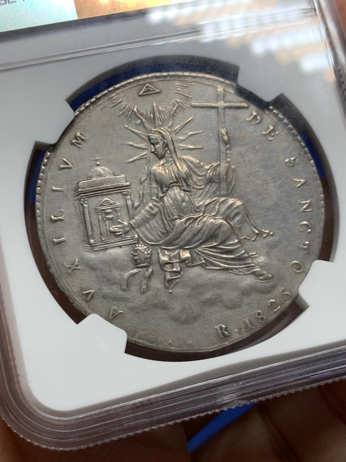 《竞宝斋》第464场 周日，周一，周二，3场连拍 （全场包邮）欢迎送拍 NGC XFD 意大利 教皇国 1825年 1斯库多 银币 精致的云端圣母题材 12点钟有一处微小的镶嵌移除痕迹 这枚的圣母头饰不同于克书版 是略弯曲的 不清楚在稀有度上是否有区别 很少见的品种