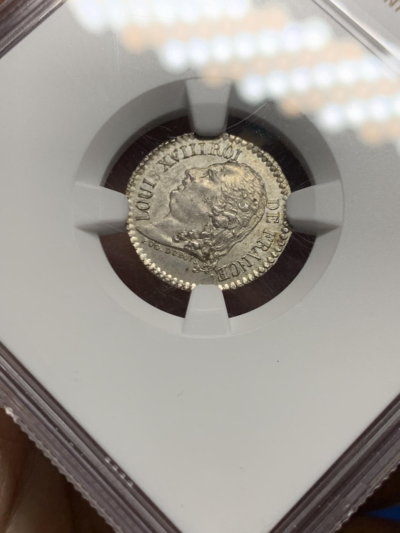 《竞宝斋》第464场 周日，周一，周二，3场连拍 （全场包邮）欢迎送拍 少见 NGC MS63 法国1818年波旁王朝复辟时期的法国银质纪念章，正面为路易十八右向肖像，环绕铭文标示其王权身份，体现复辟初期法国重新确立合法君主统治的政治语境。背面人物为亨利四世右向肖像，其形象源自法国王权传统中被反复引用的“王国奠基者”形象，用以强调王朝合法性的历史延续性。正反两面并置不同君主，是复辟时期常见的纪念性设计，用以将当下政权与历史上的成功统治者相连接。